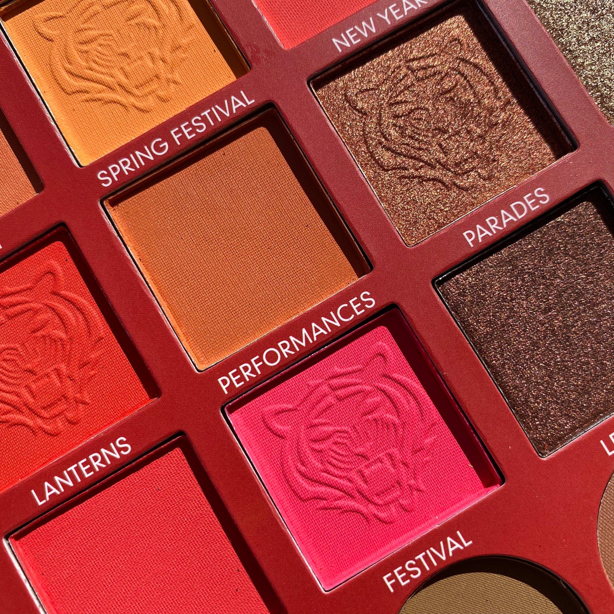Eyeshadow palette with multiple colors, patterned shades, and red frame