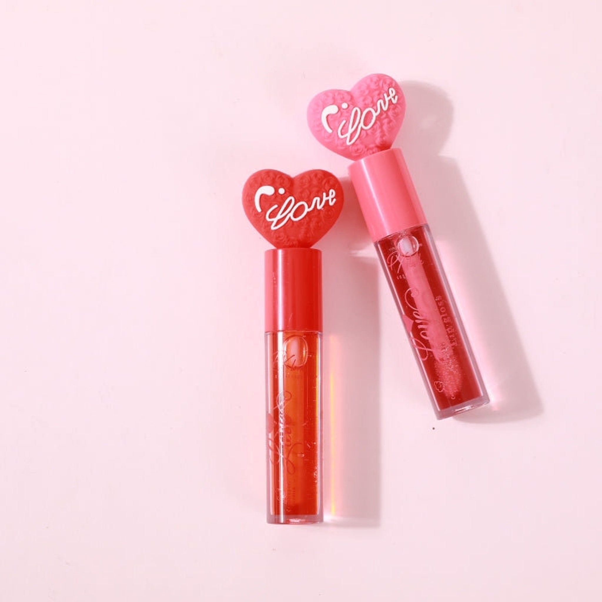 PXLOOK Love Lip Gloss in sleek silver tube with heart-shaped logo on black background