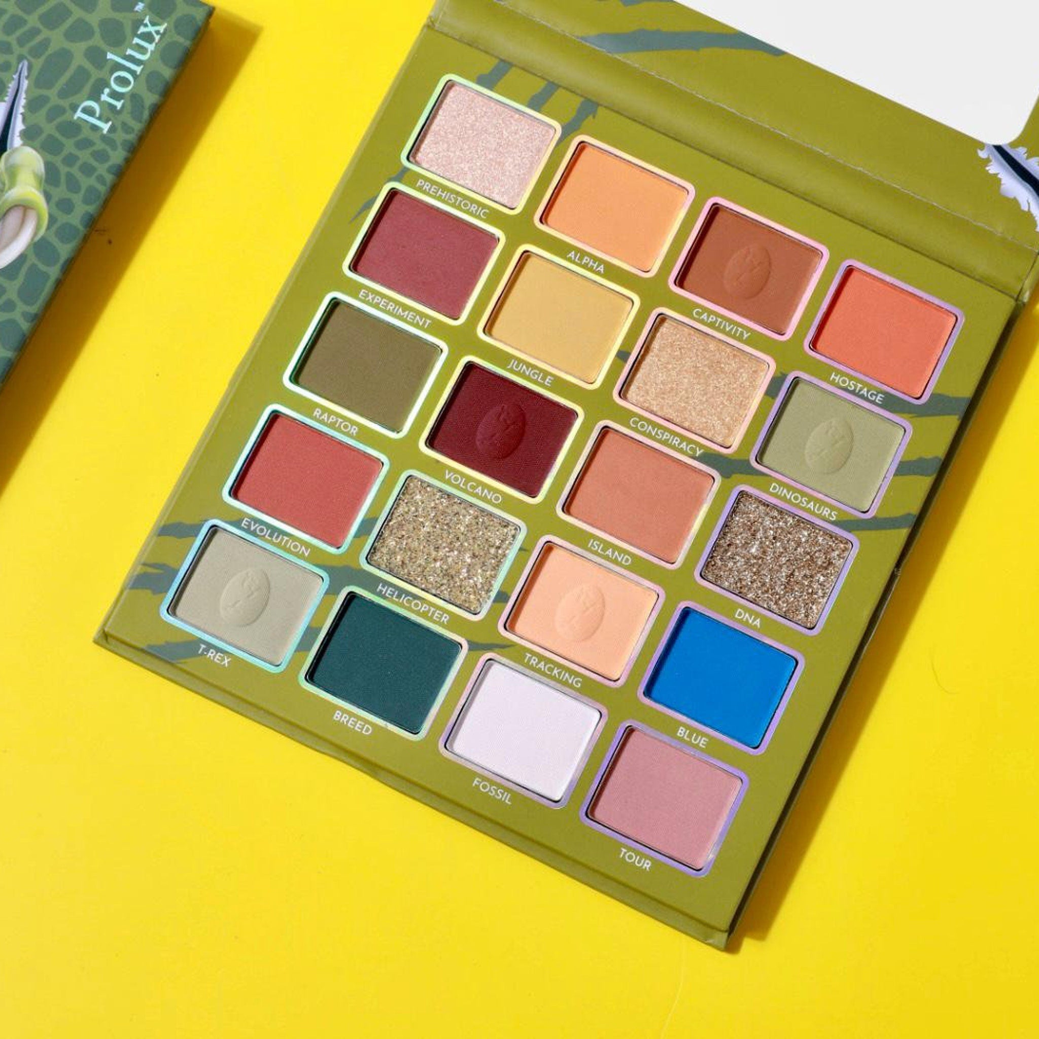Eyeshadow palette with multiple colors, green and white Prolux packaging, and yellow background