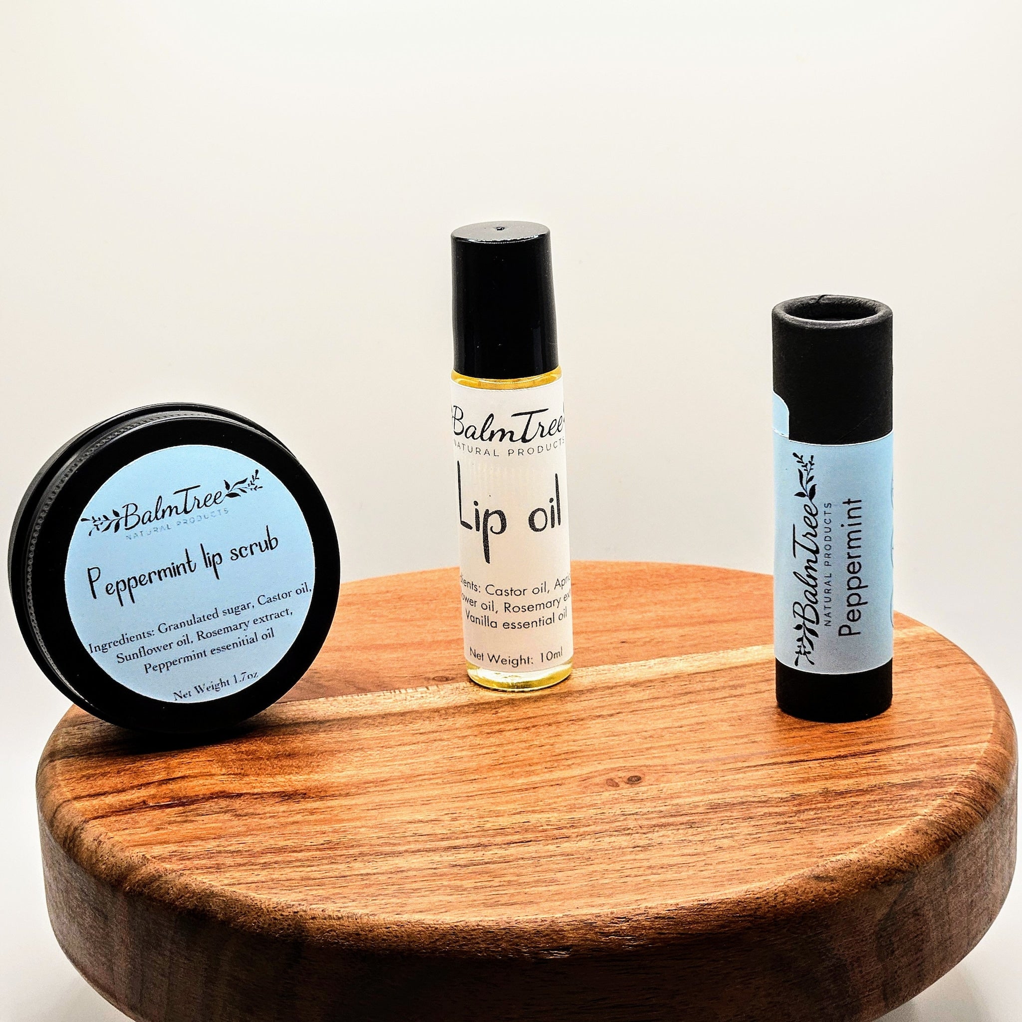 Lip care products with black containers and wood display, Balmtree brand visible