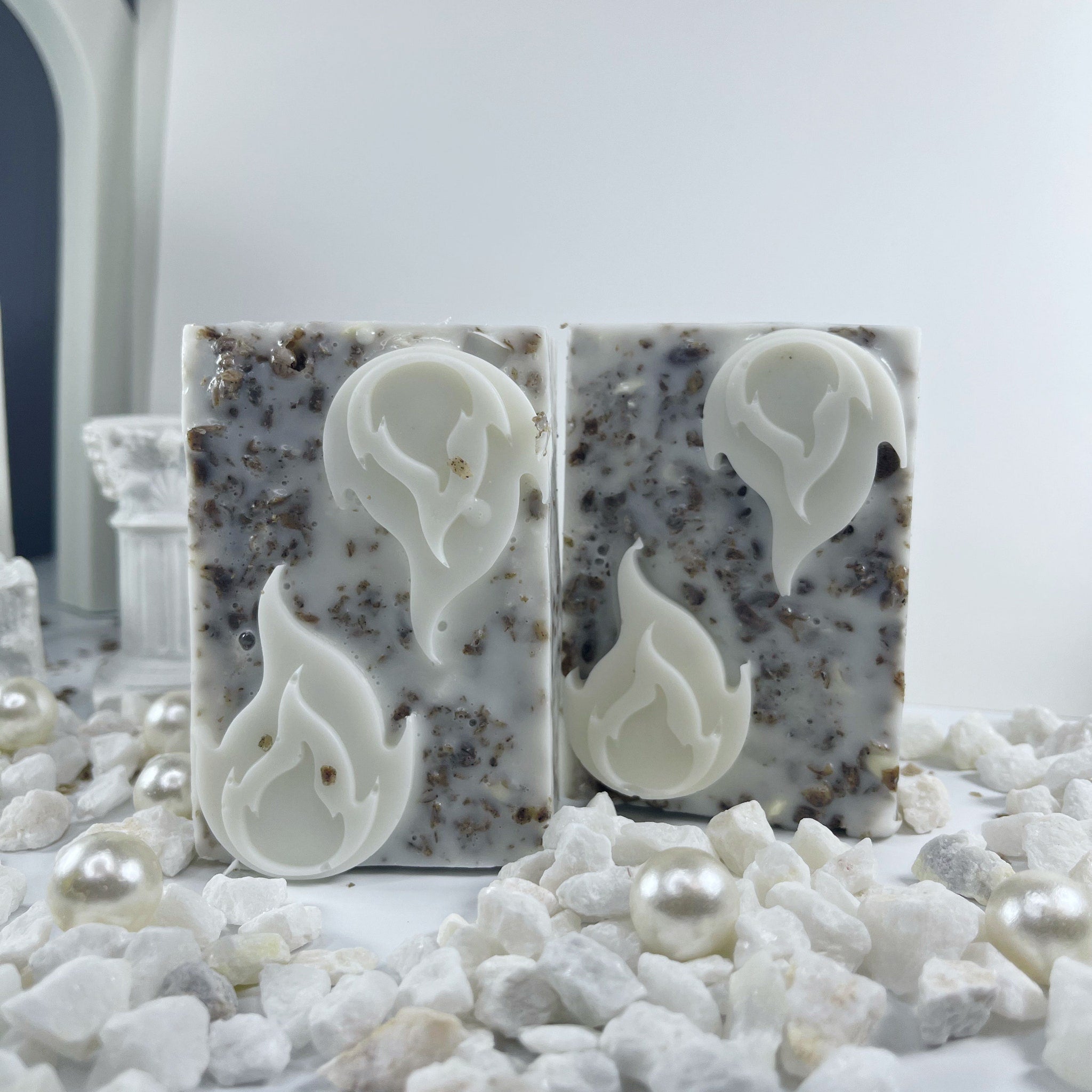 Soap bars with white flame design, speckled pattern, and white accents on white stones