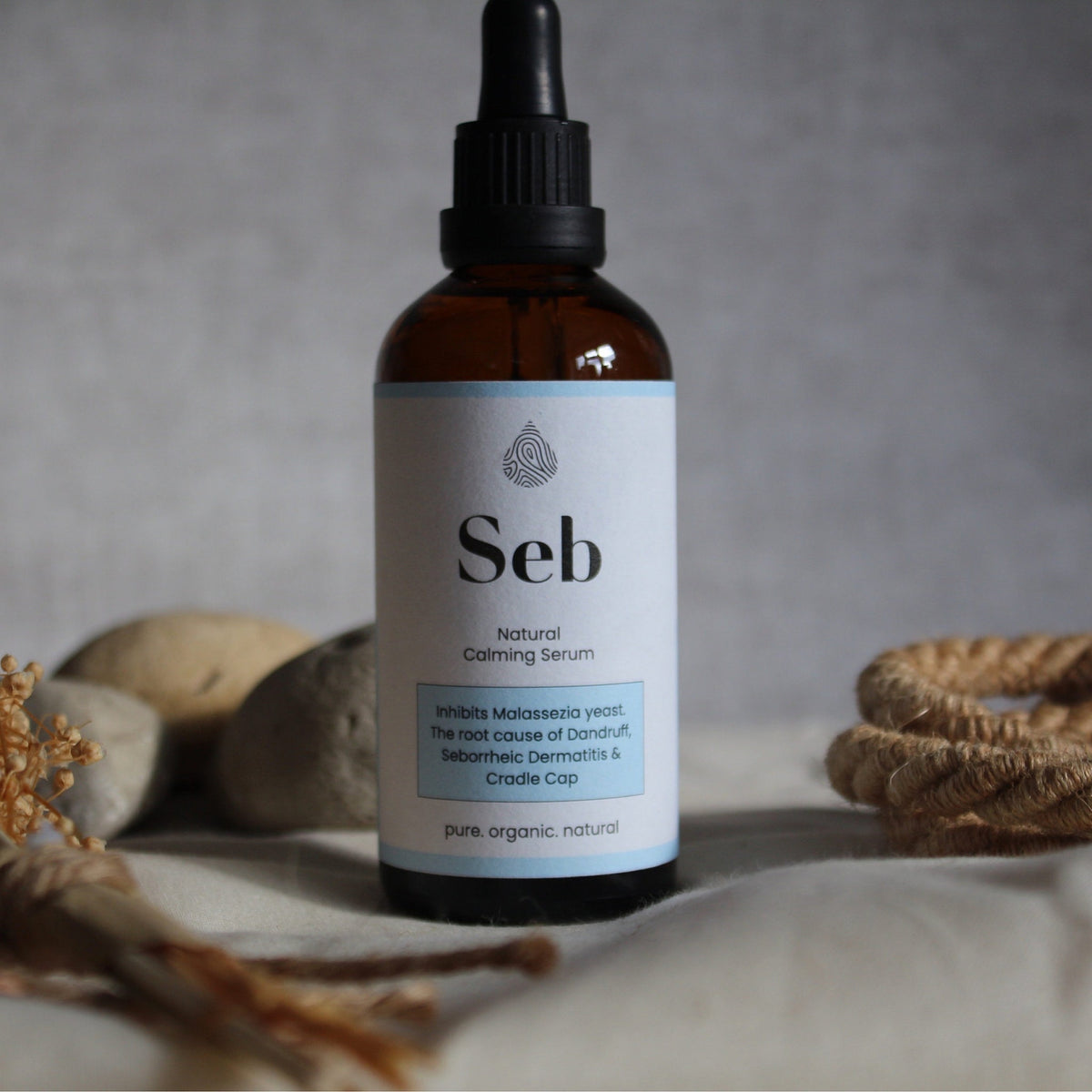 Side view of sleek white serum bottle with dropper cap, showcasing 100ml size and minimalist branding on matte label