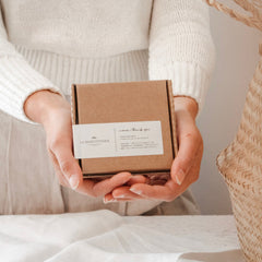 La Marcotterie gift box, brown cardboard, white label, held by hands, merci thank you text visible