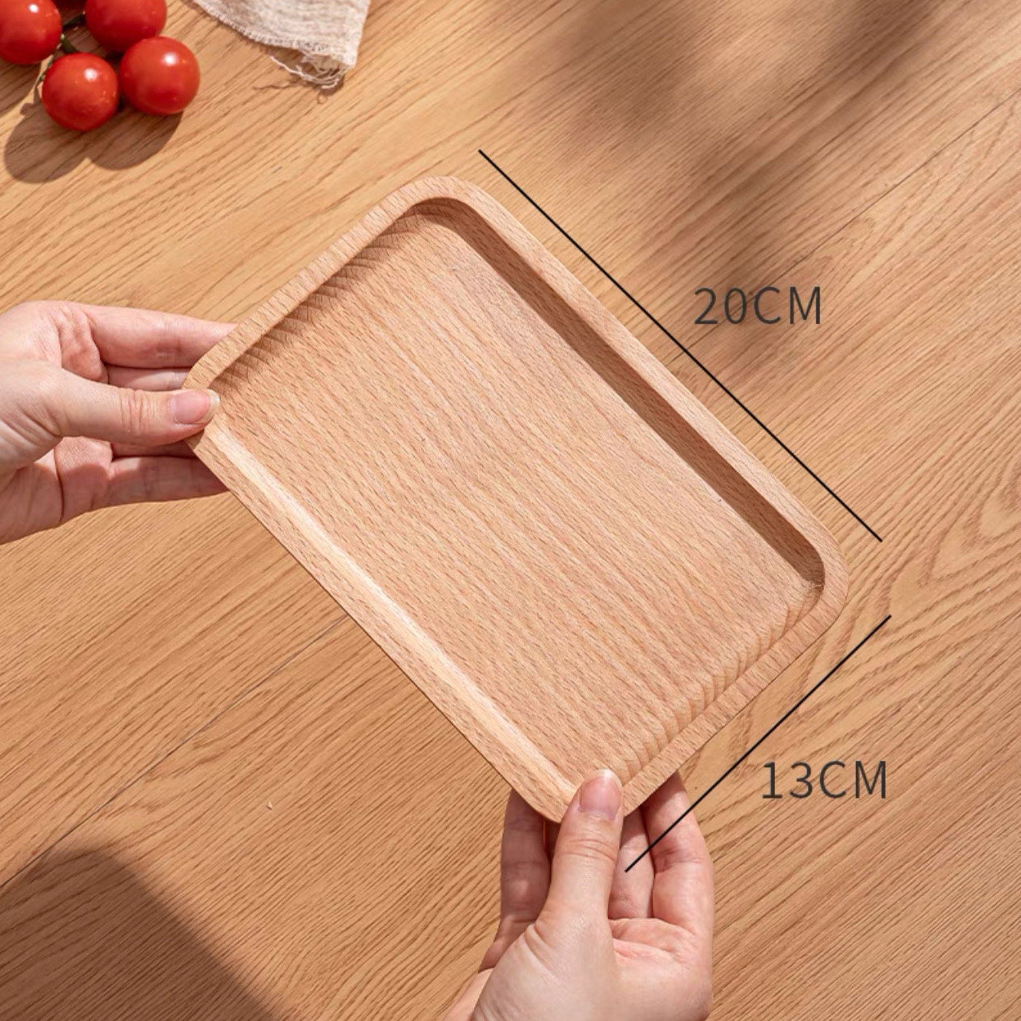 Wooden serving tray, light brown wood grain, rectangular shape, held by hands