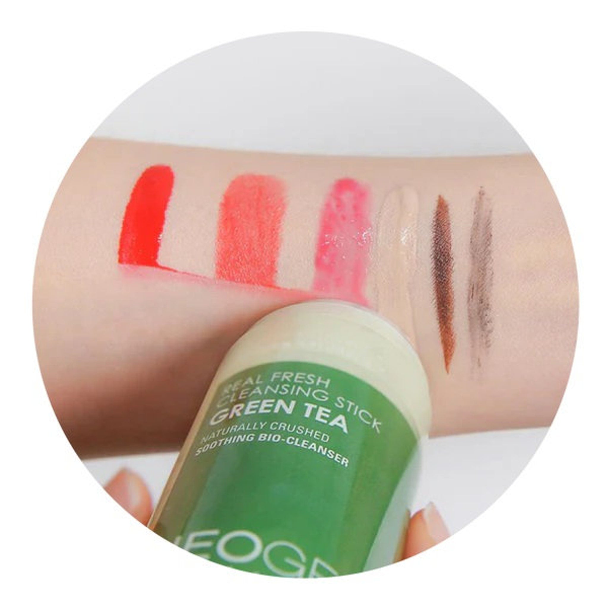 Lipstick swatches in red, pink, and brown with green and white cleansing stick, on skin