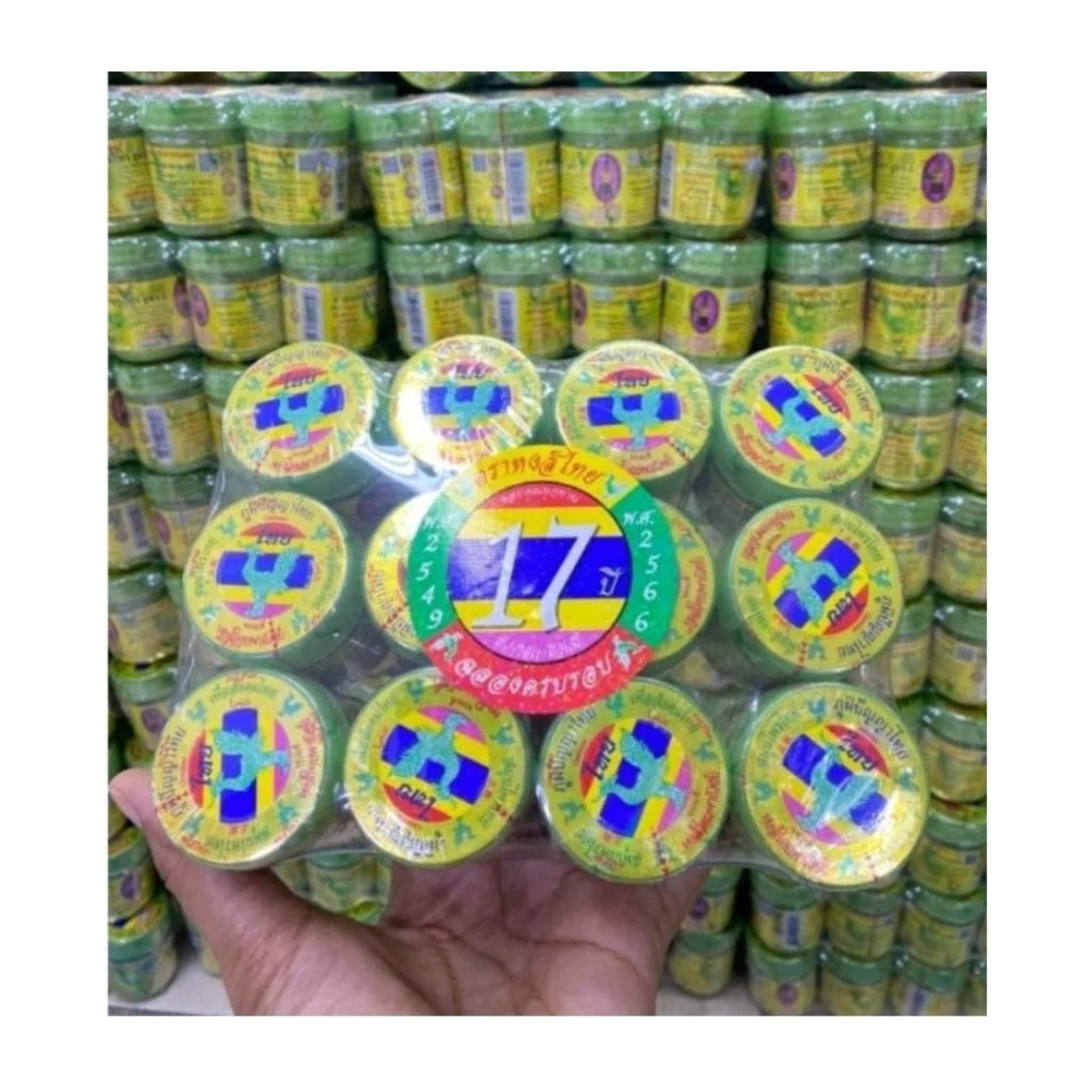 Green jar with yellow label, blue cross logo, and Thai text, in plastic packaging