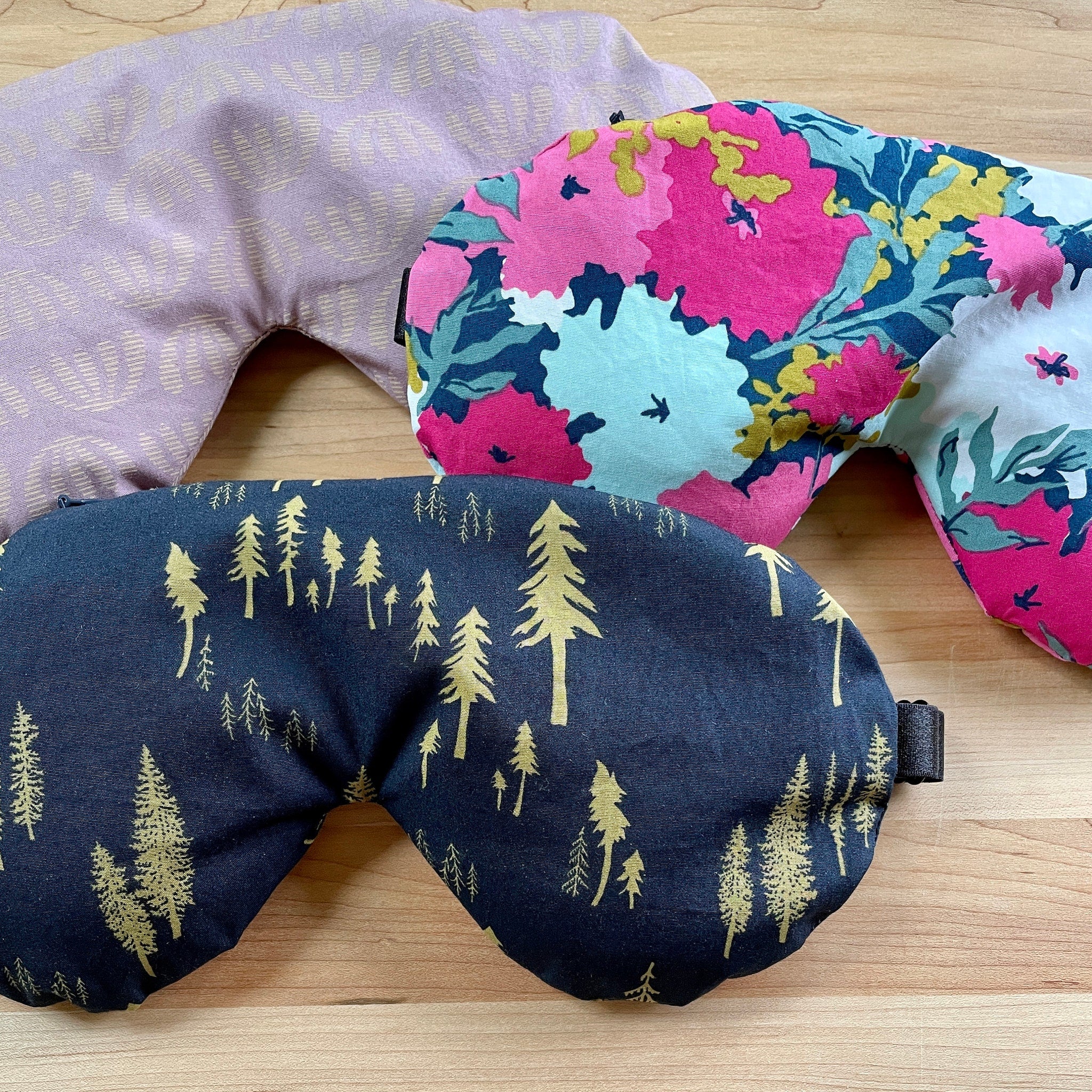 Sleep masks with floral, tree, and patterned designs in various colors and styles