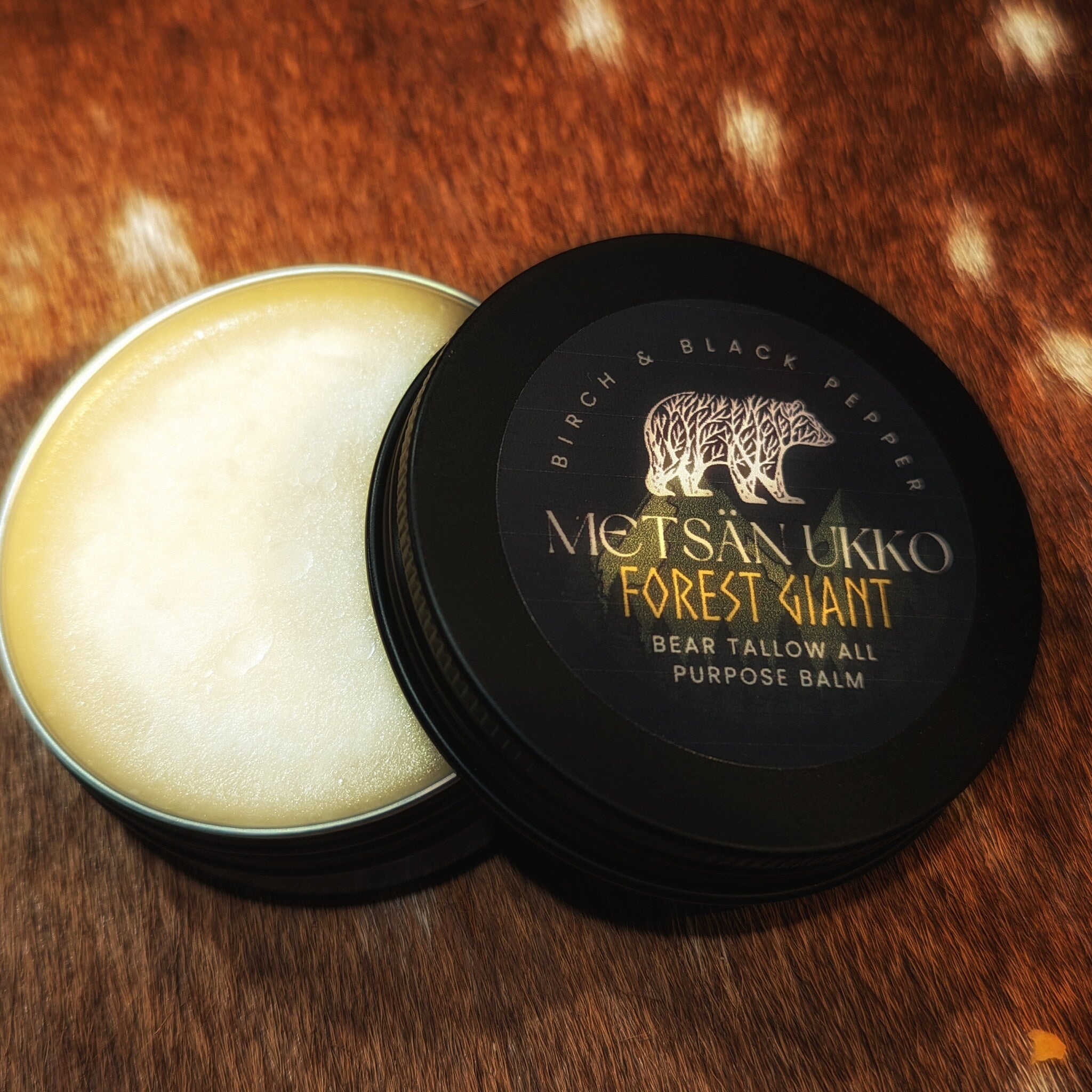 Balm jar with black lid, light yellow balm, and brand label on a brown fur background