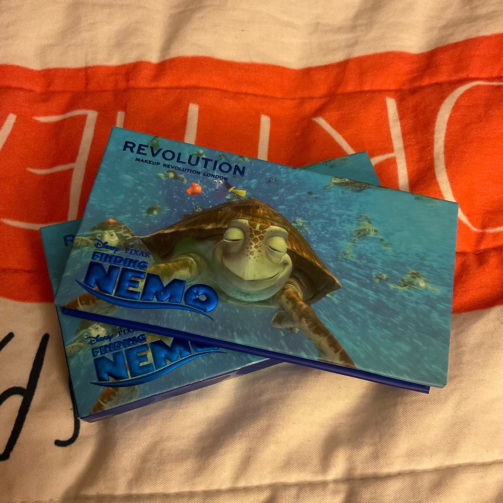 Close-up of Disney Finding Nemo Crush Eyeshadow Palette showing six vibrant ocean-inspired shades with turtle imprint