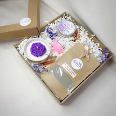 Gift box with purple flower candle, pink bath bomb, and GABIWORKS branding on brown box