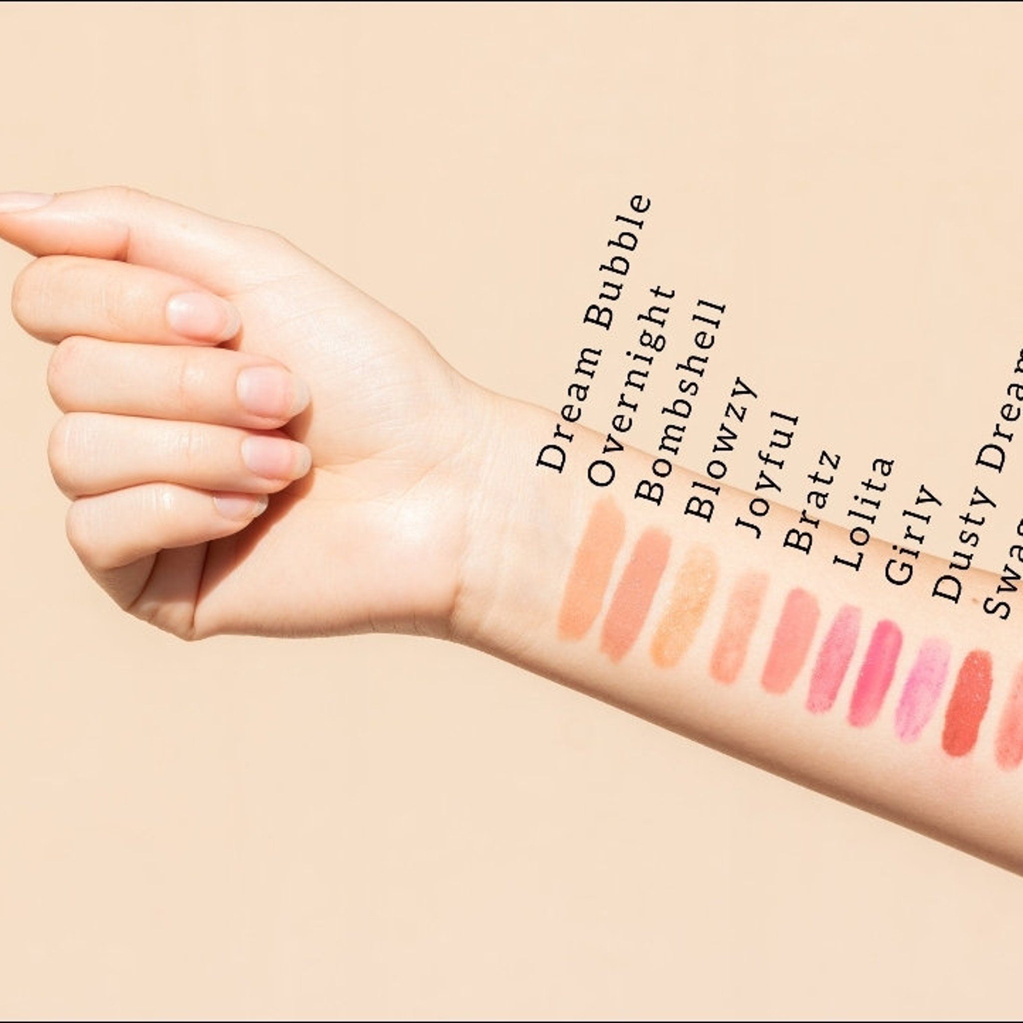 Lipstick swatches in various shades of pink and coral on arm for color comparison