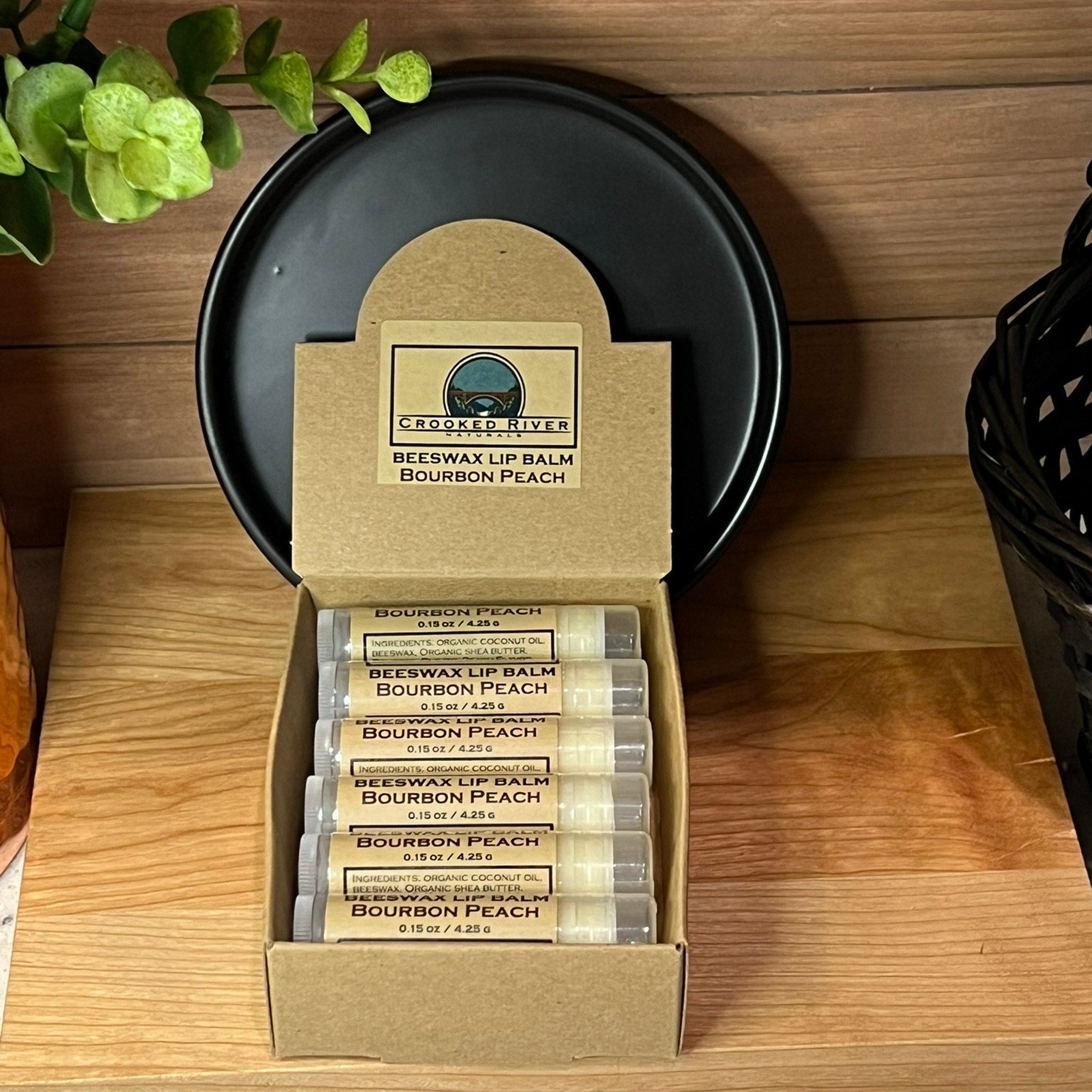 Beeswax lip balm in clear tubes with brown label, inside a cardboard box, Crooked River brand