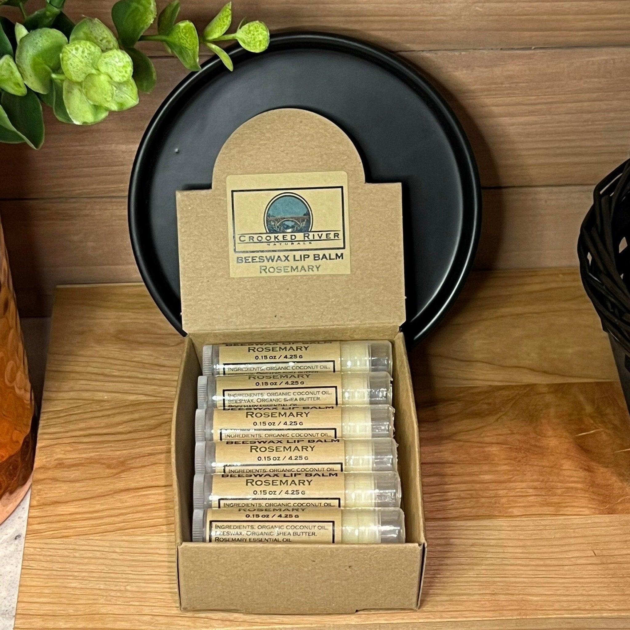 Beeswax lip balm tubes in a cardboard box, Rosemary flavor, Crooked River Naturals brand visible