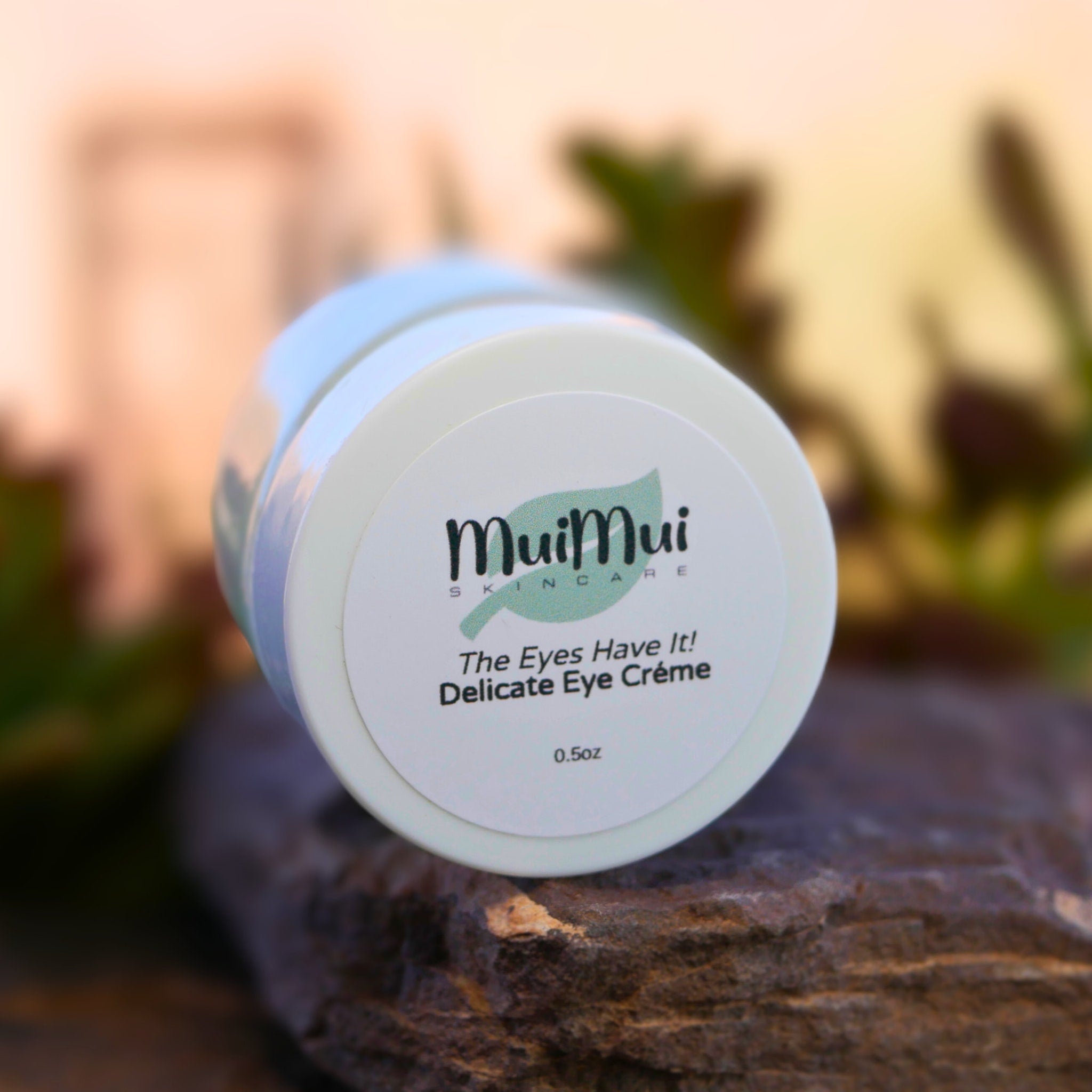 Eye cream jar with white label, light blue and white lid, Mui Mui Skincare logo visible
