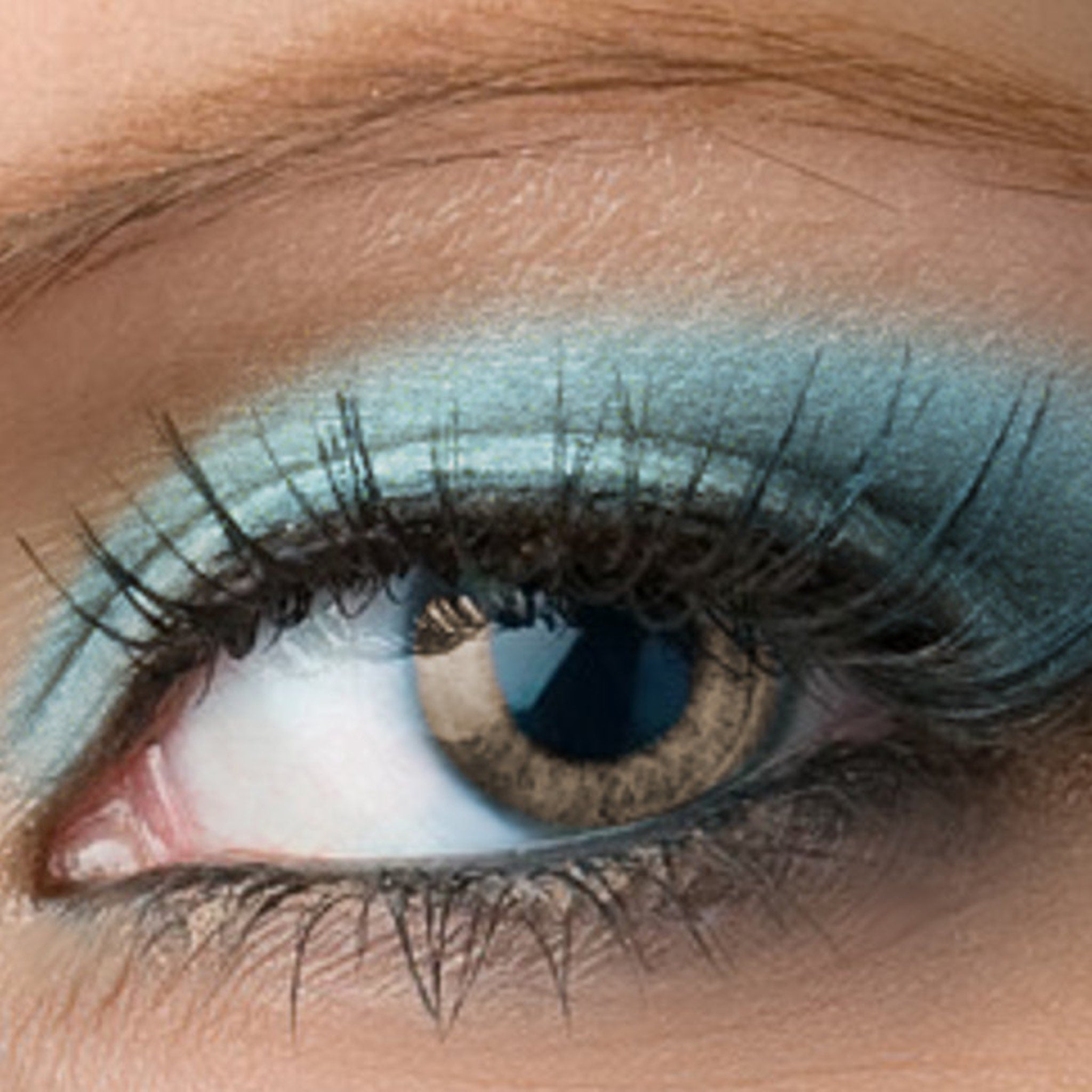 Close-up of shimmering frosty aqua blue mineral eyeshadow with sparkling flecks in compact pan