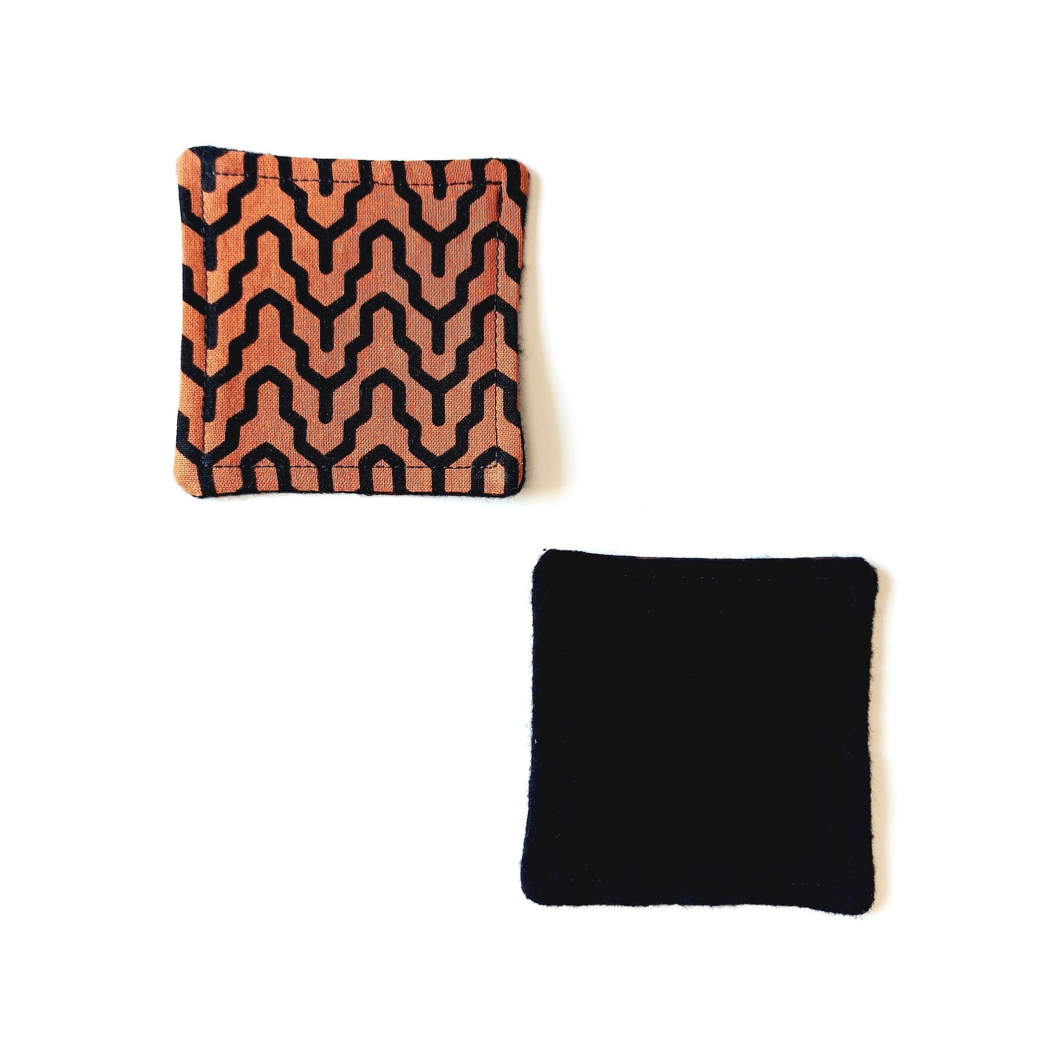 Coasters with orange and black geometric pattern, and solid black fabric square