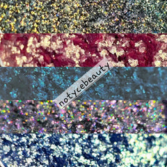 Hand applying shimmery multichrome eyeshadow with fingertip, showing color shift from purple to green