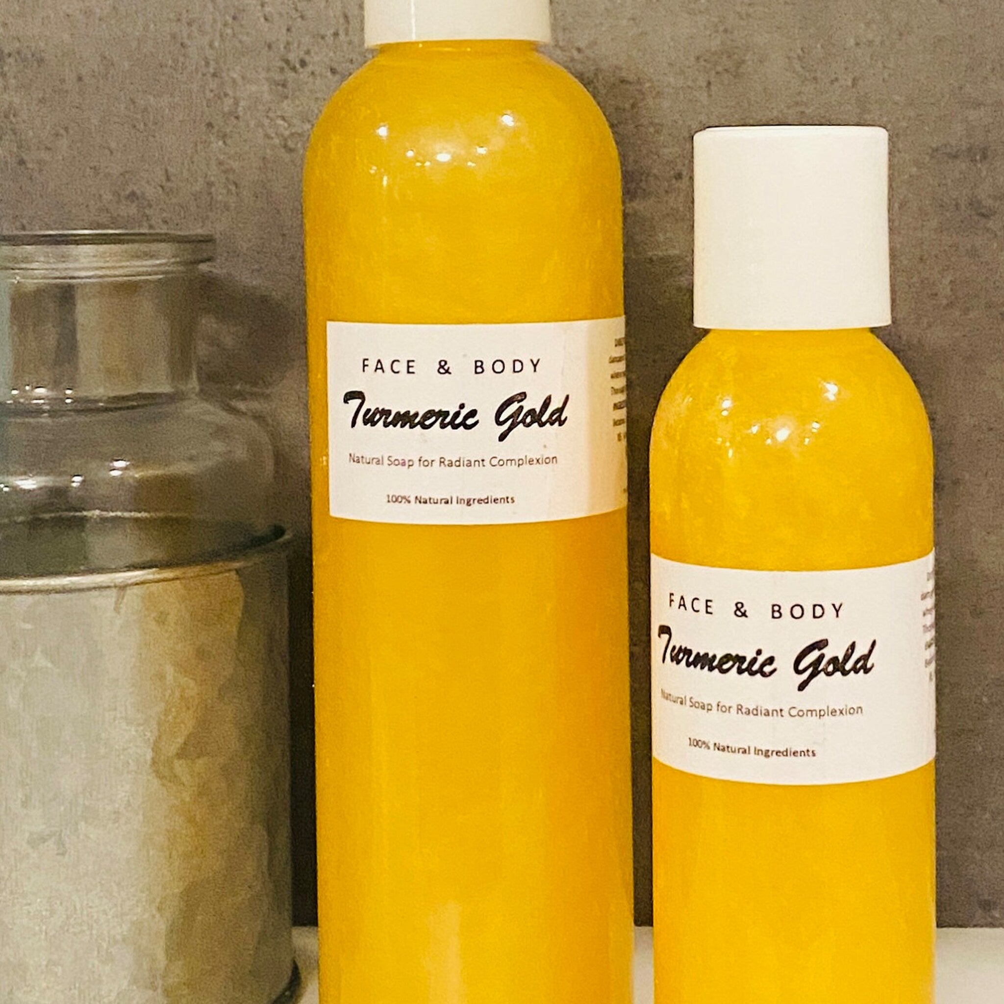Close-up of golden turmeric liquid soap in clear bottle with loofah, showing rich foaming texture and natural ingredients