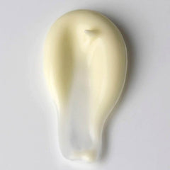 Creamy yellow lotion smear with a white background, showing texture and consistency of the product.