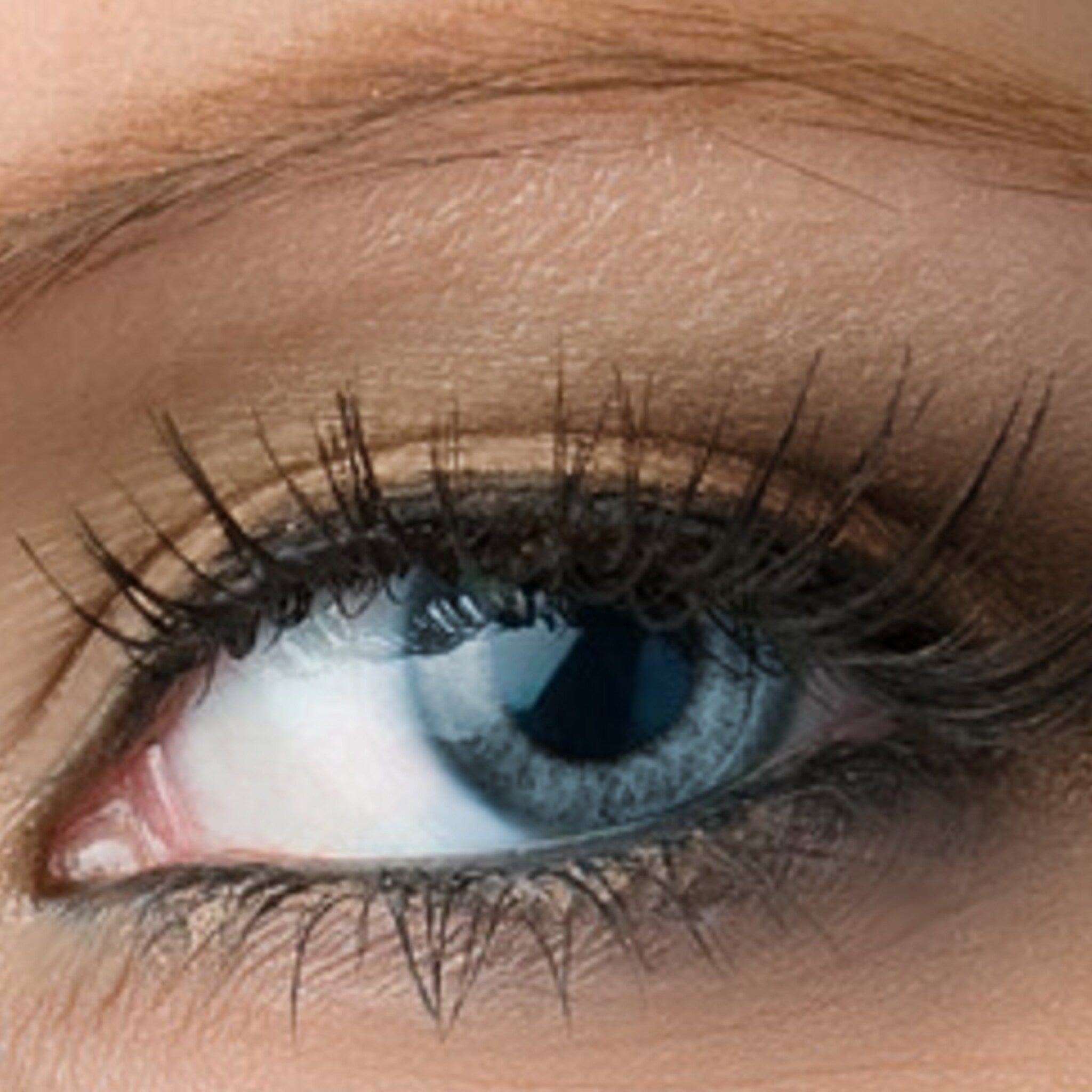 Eye close-up with blue iris, dark eyelashes, and light skin texture detail