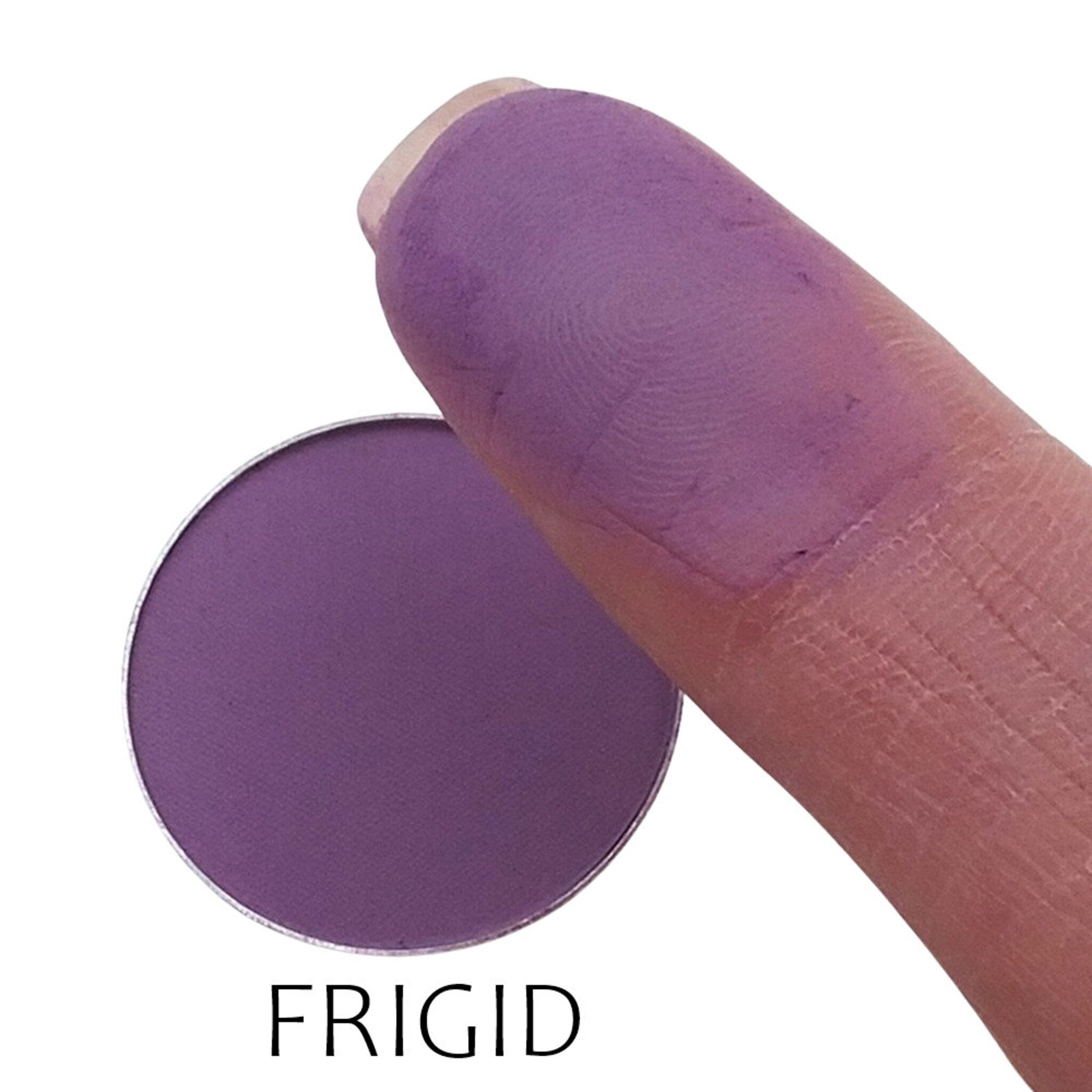 Close-up of matte frigid eyeshadow pan showing smooth powder texture and cool-toned grayish-blue hue