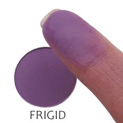 Close-up of matte frigid eyeshadow pan showing smooth powder texture and cool-toned grayish-blue hue