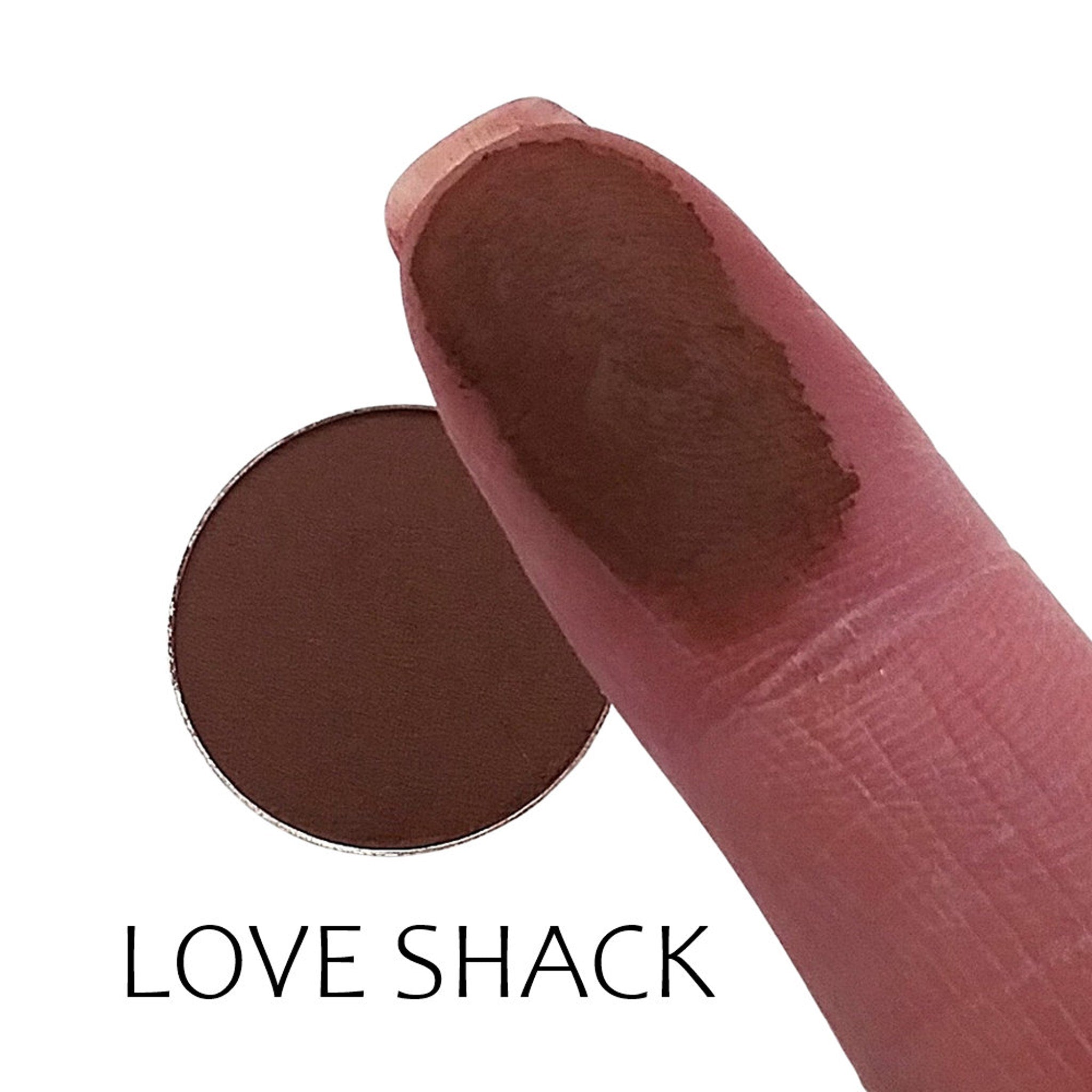 Close-up of matte taupe eyeshadow pan with smooth, velvety texture in compact packaging