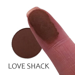 Close-up of matte taupe eyeshadow pan with smooth, velvety texture in compact packaging