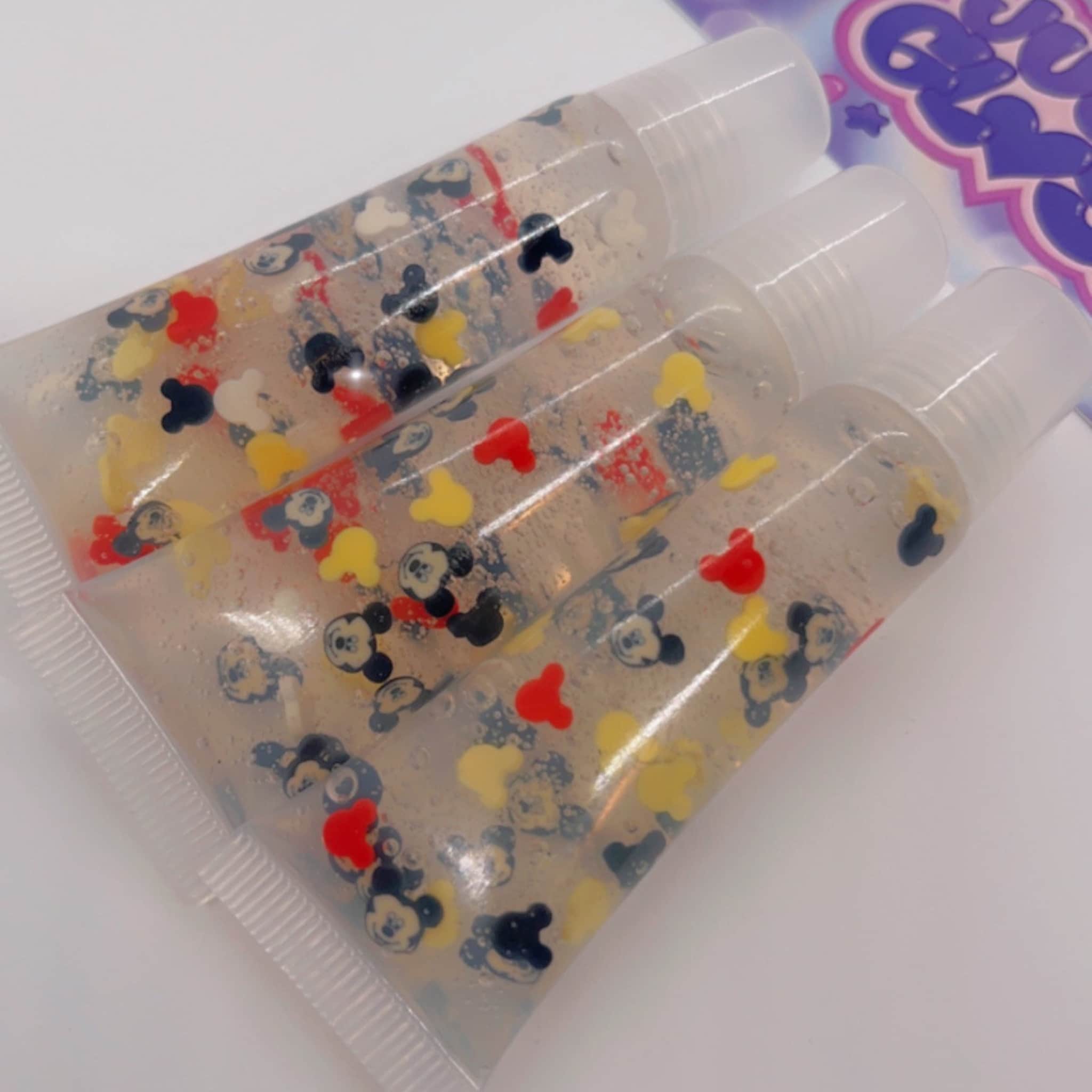 Lip gloss tubes with Mickey Mouse shapes in red, yellow, and black, clear liquid inside