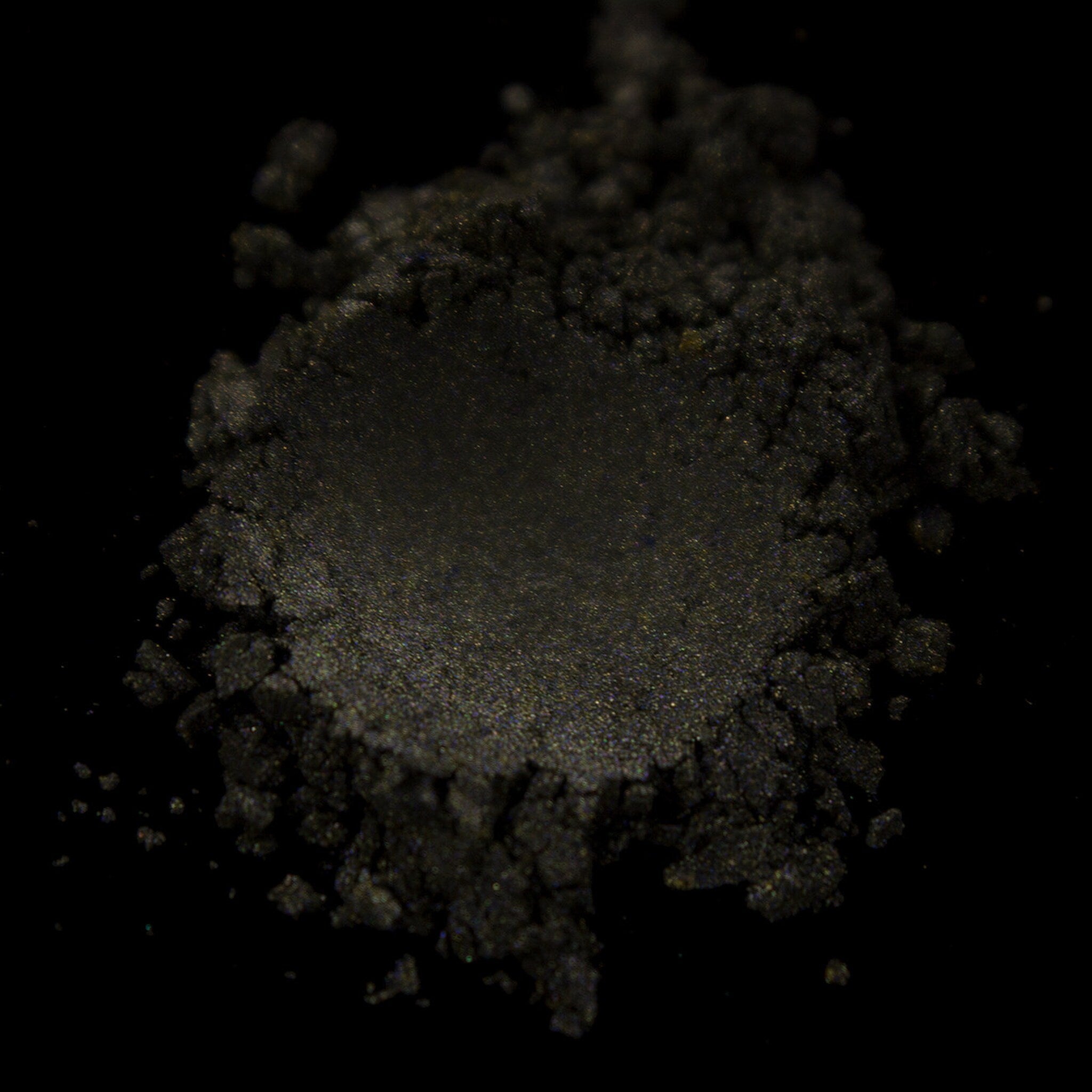 Close-up of pressed taupe eye shadow with shimmer finish in compact pan, showcasing cool neutral undertones