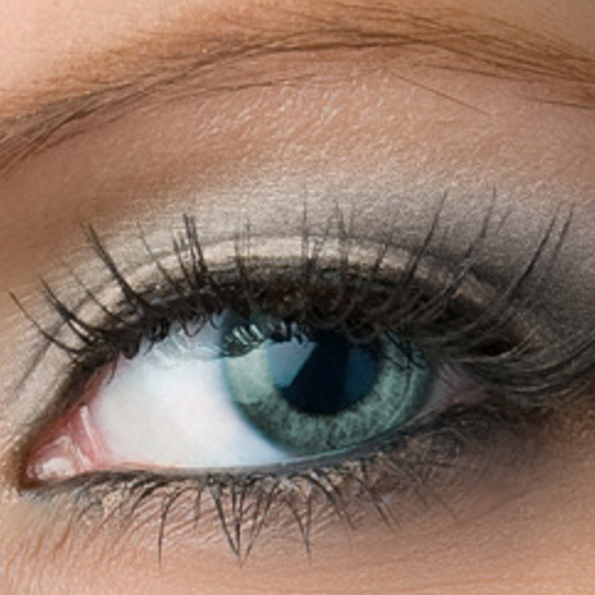 Eye with blue iris, long black eyelashes, and light brown skin tone