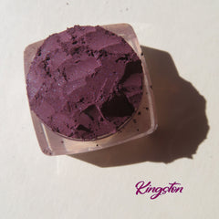Close-up of dark purple shimmer vegan mineral eye shadow in loose powder form with eco-friendly packaging