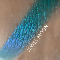 Side view of Jewel Moon Chrome Shifting Eyeshadow pot showing iridescent multi-color shimmer particles