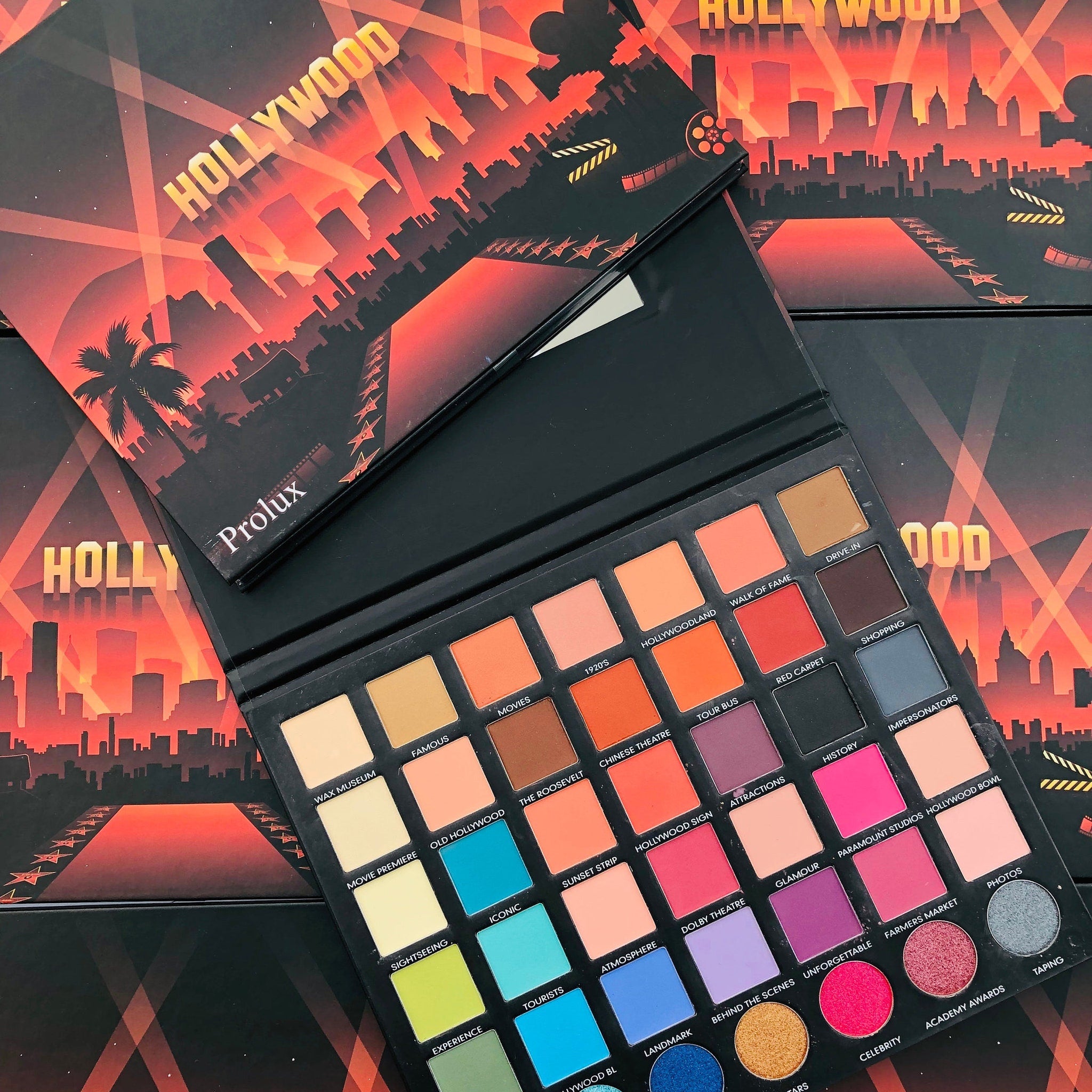 Eyeshadow palette with multiple shades, black case, and Hollywood themed cover art by Prolux
