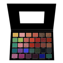 Eyeshadow palette with various colors in a black compact, for makeup application.