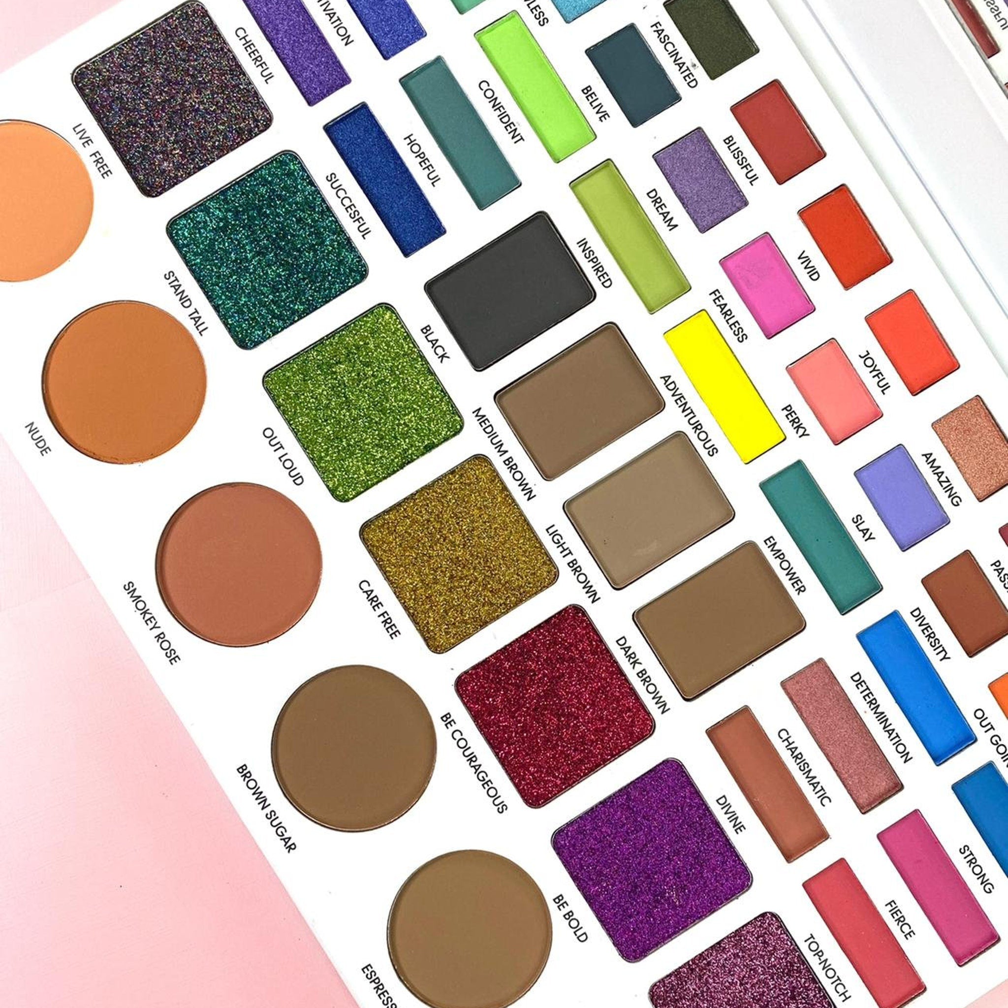 Eyeshadow palette with various colors, including matte, shimmer, and glitter finishes, in rectangular and round pans