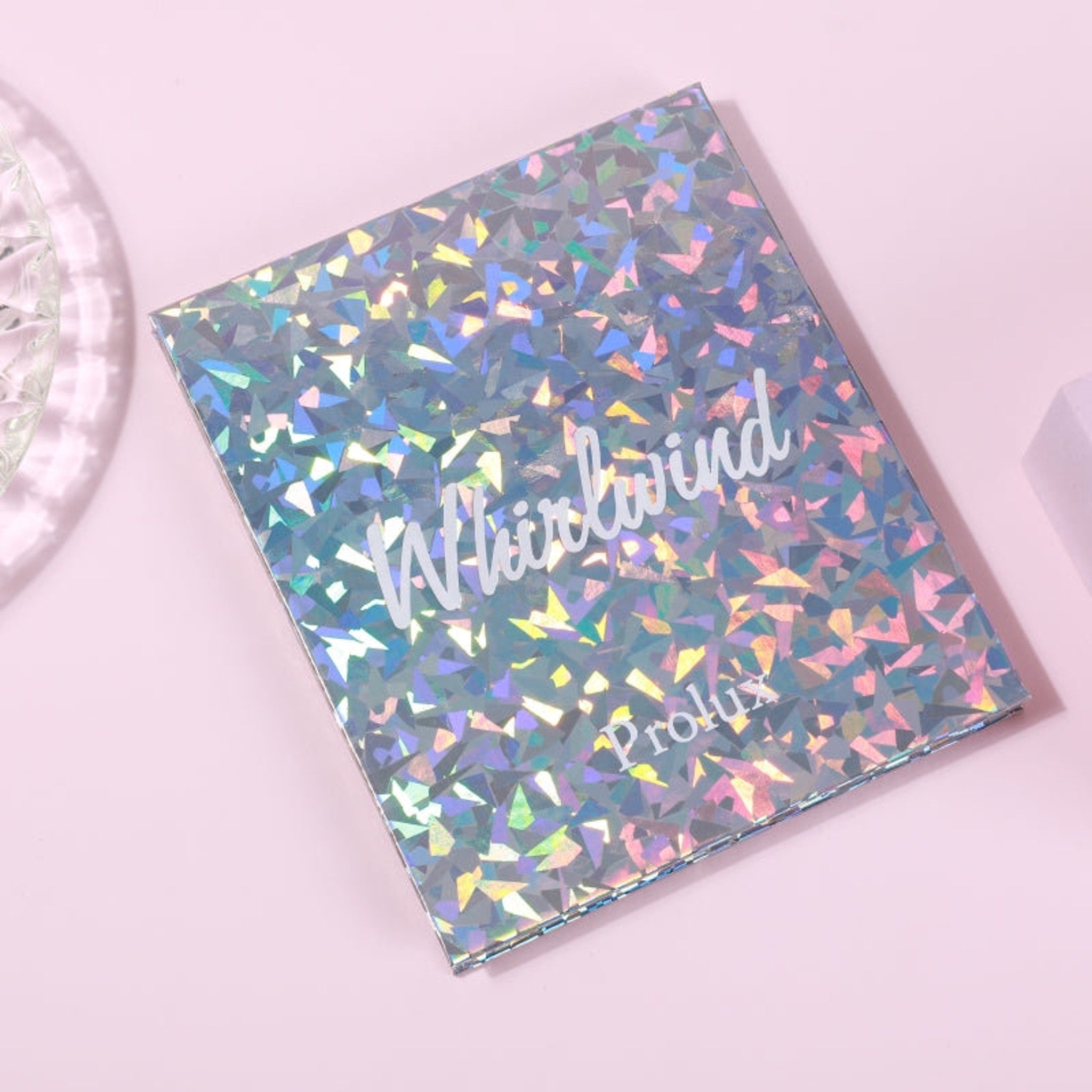 Holographic box with geometric pattern and "Whirlwind" text on pink background