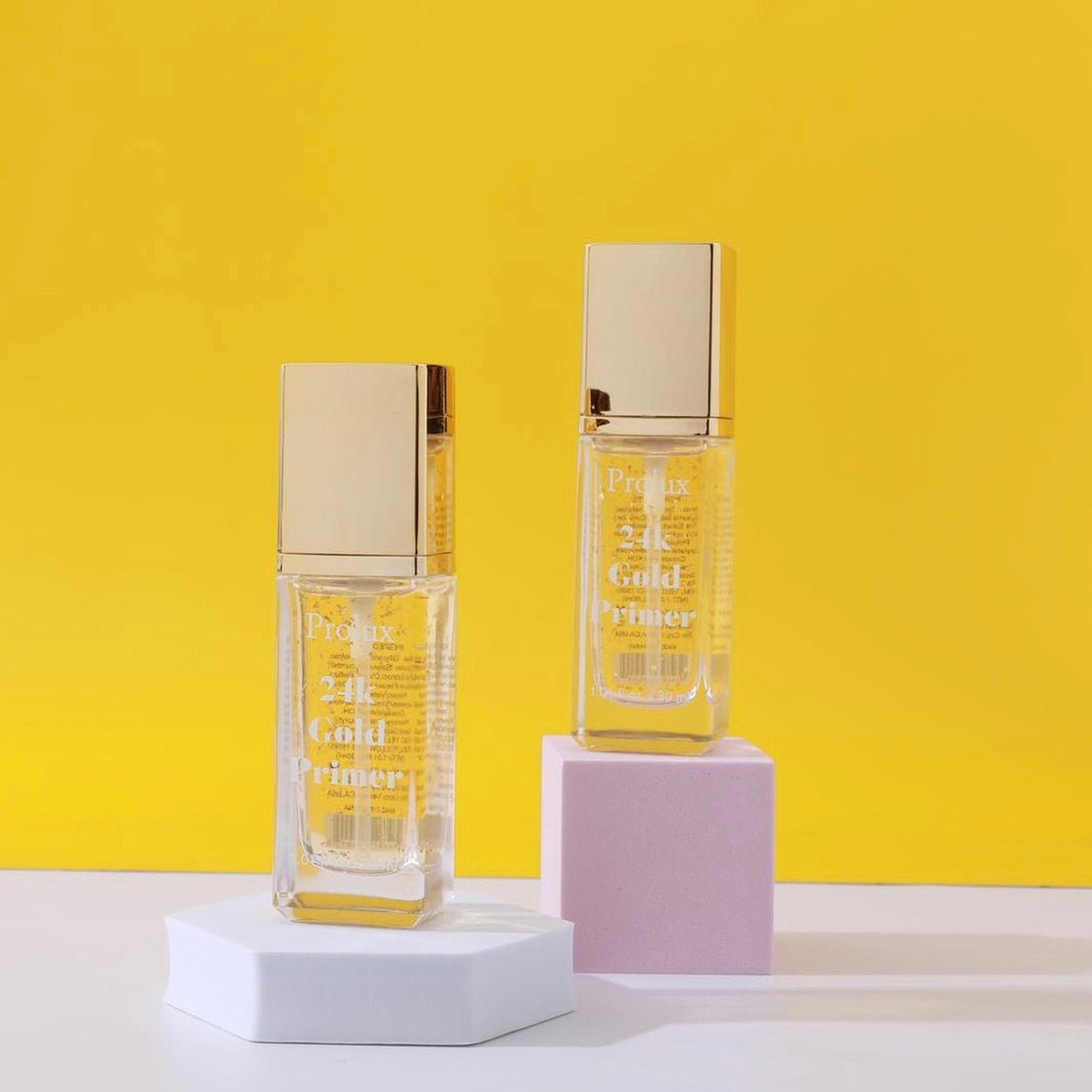Primer bottles with gold cap and clear glass, displayed on white and pink blocks with yellow background