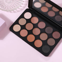 Eyeshadow palette with multiple shades, black compact, and mirror reflection
