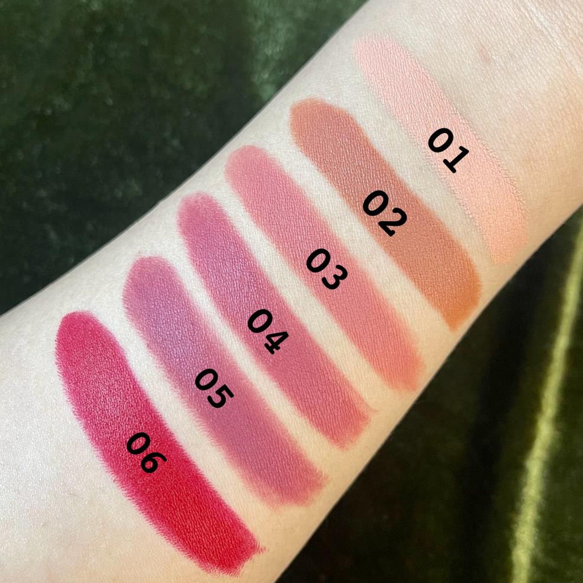 Close-up of PXLOOK lipstick bullet showing creamy satin finish in vibrant pink shade with gold-toned casing