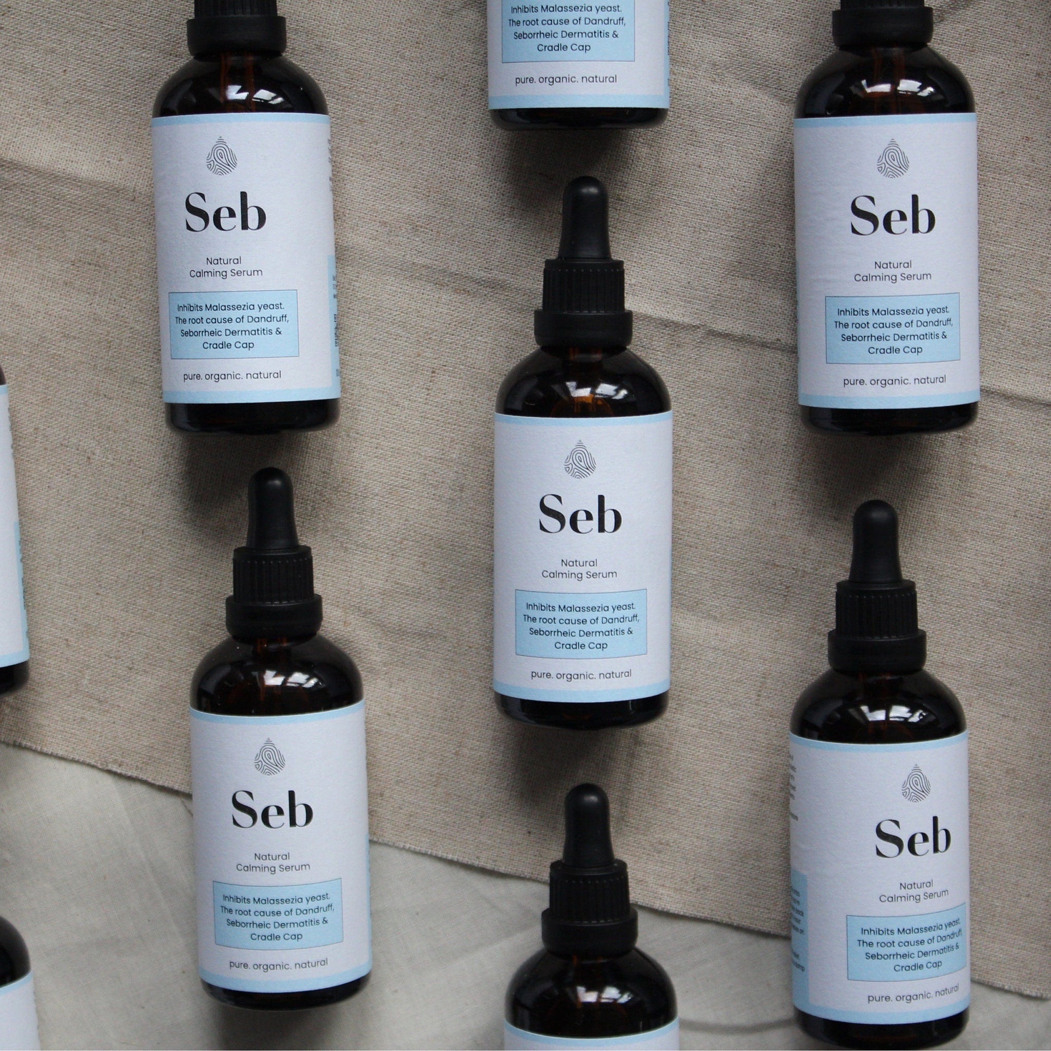 Matte glass bottle of sebum-calming serum with sleek black dropper and minimalist gold branding