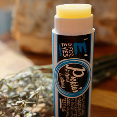 Eye balm stick with yellow balm, white and blue label, E is for Eyes brand visible