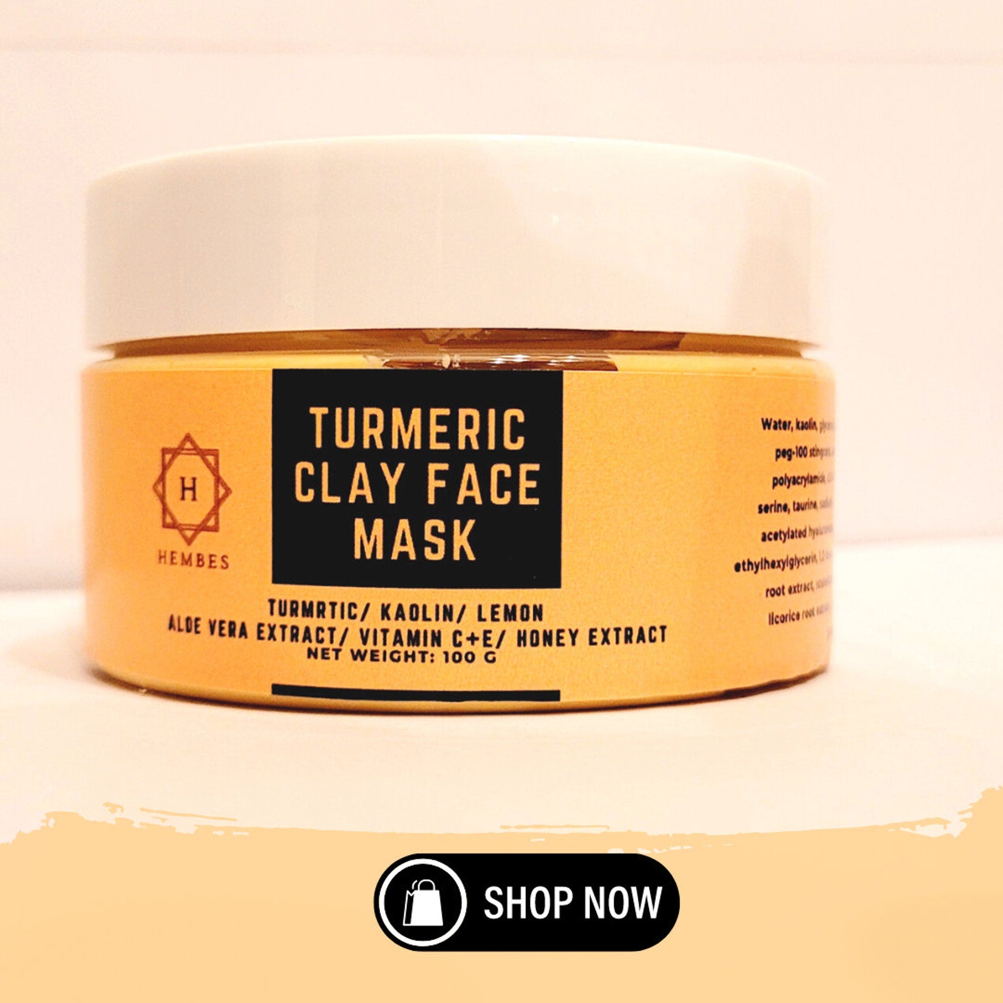 Side view of golden turmeric clay mask jar with minimalist label on marble surface