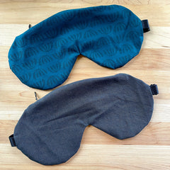 Sleep masks in teal patterned fabric and dark gray denim-like material, eye covering style