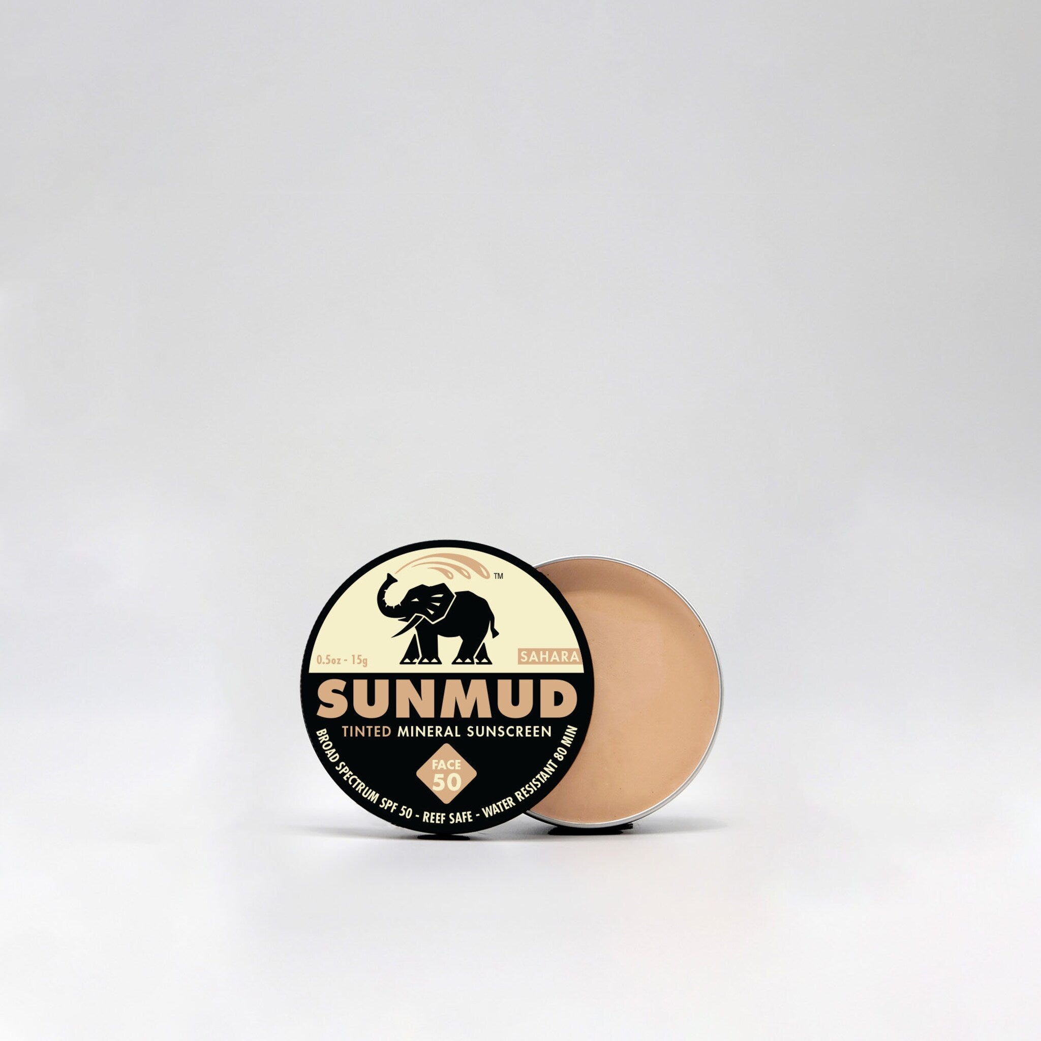 Tinted sunscreen in beige and black packaging, SUNMUD brand visible, open lid showing product