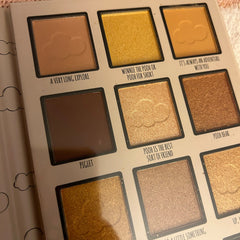 Close-up of makeup brush applying shimmering honey gold eyeshadow from Winnie the Pooh palette on eyelid