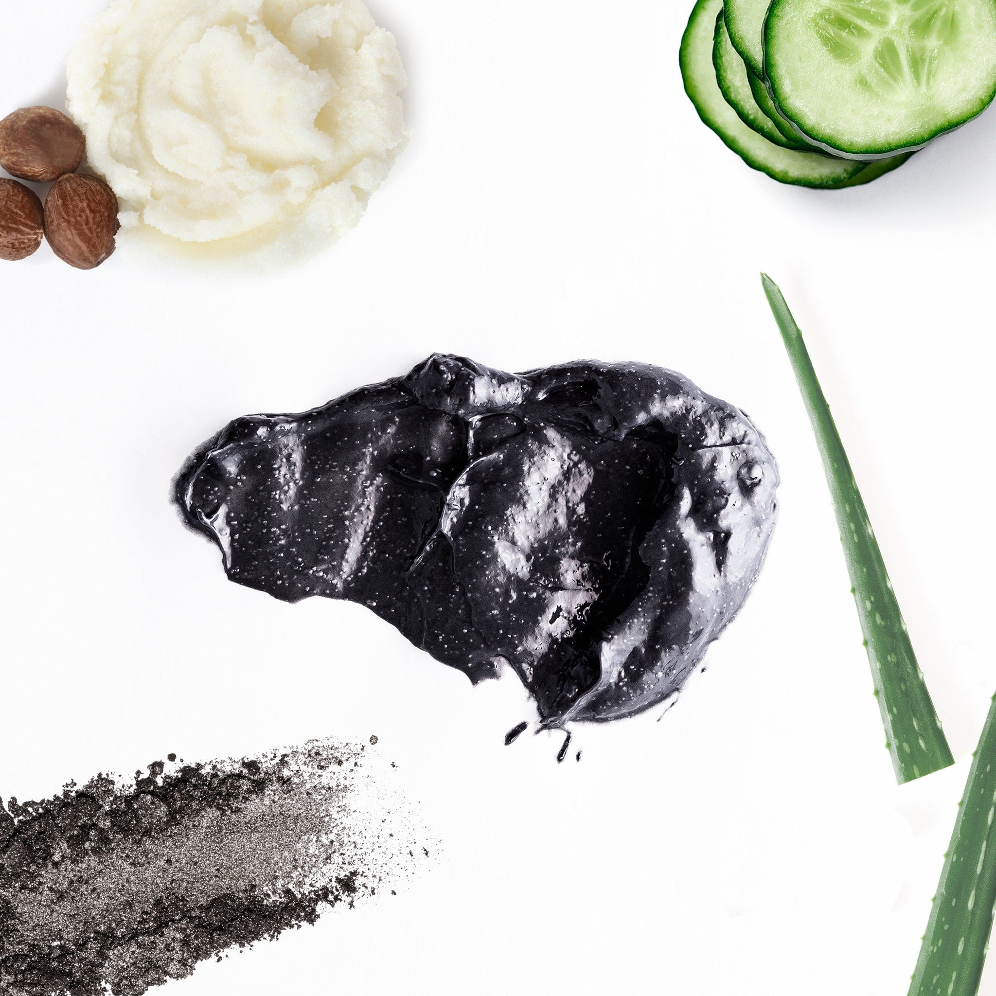 Black charcoal mask with white specks, green aloe vera, and cucumber slices on white background