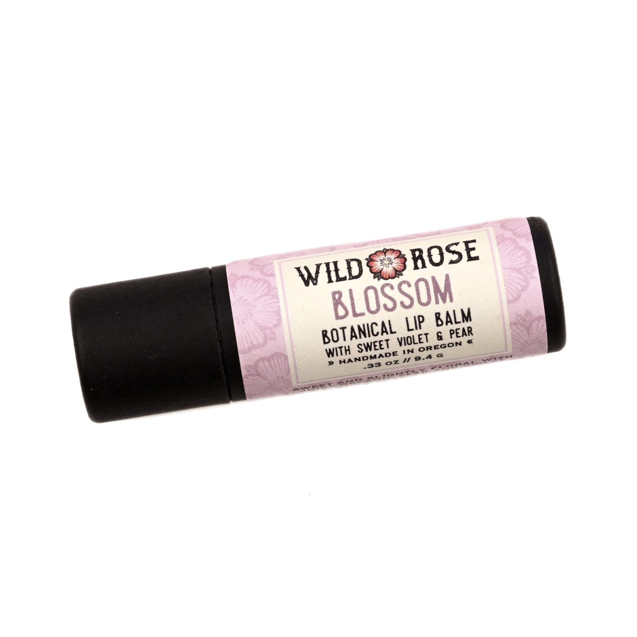 Lip balm tube with black cap, pink floral pattern, and Wild Rose Blossom label