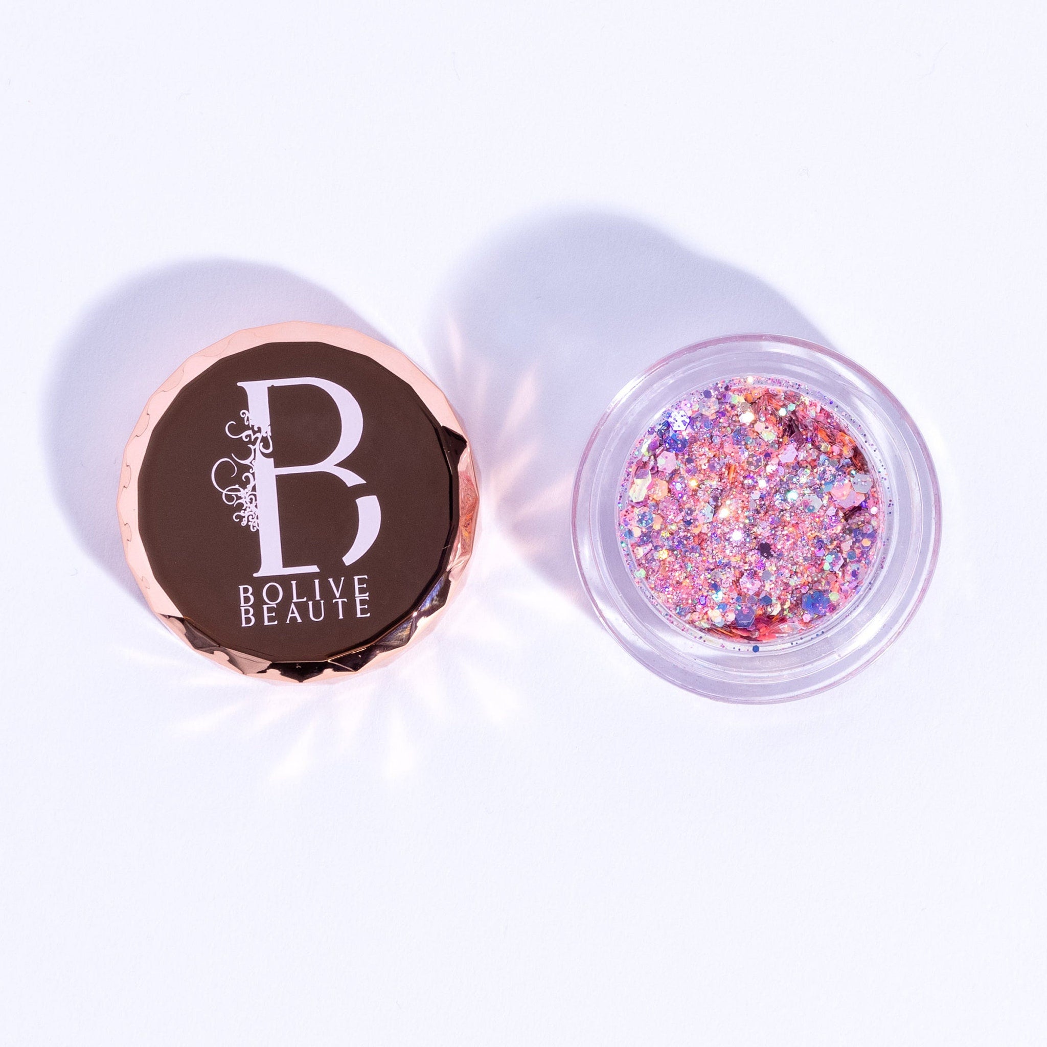 Pink glitter eyeshadow with rose gold lid, clear container, and "BOLIVE BEAUTE" text