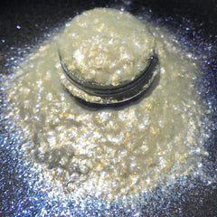 Close-up of iridescent loose eye shadow pigment shifting between white and blue hues